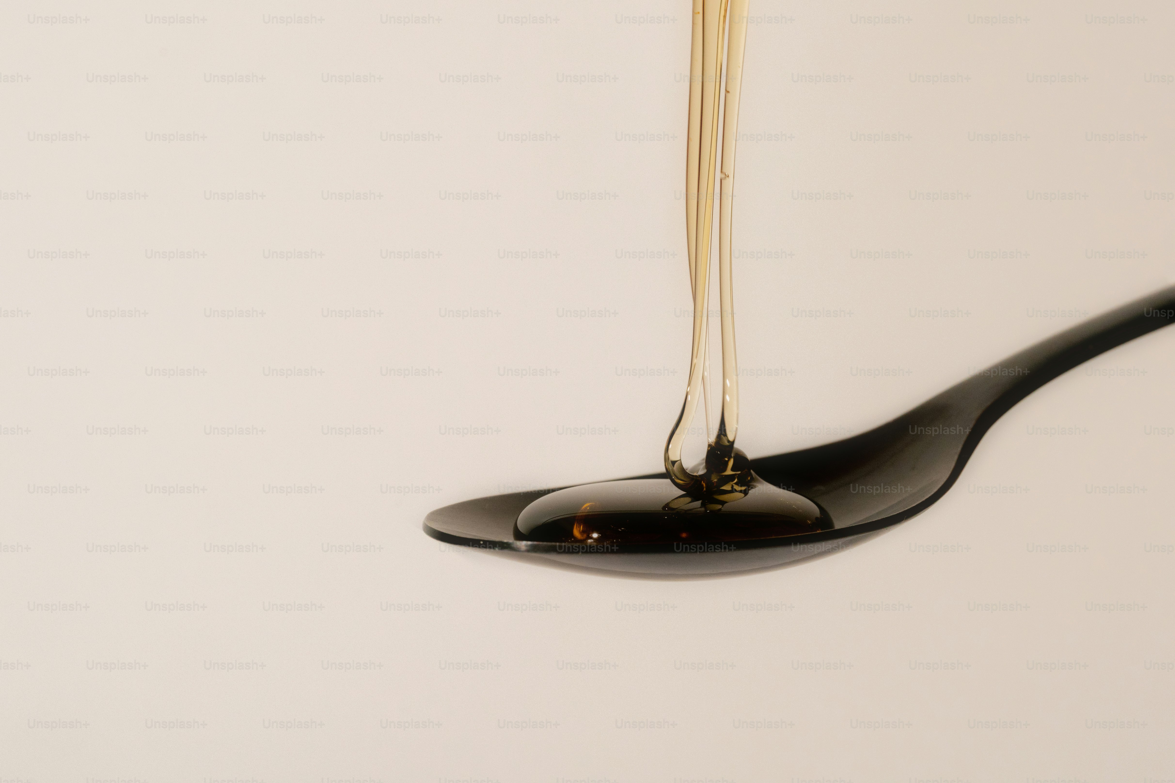 Syrup is dripping onto a black spoon.