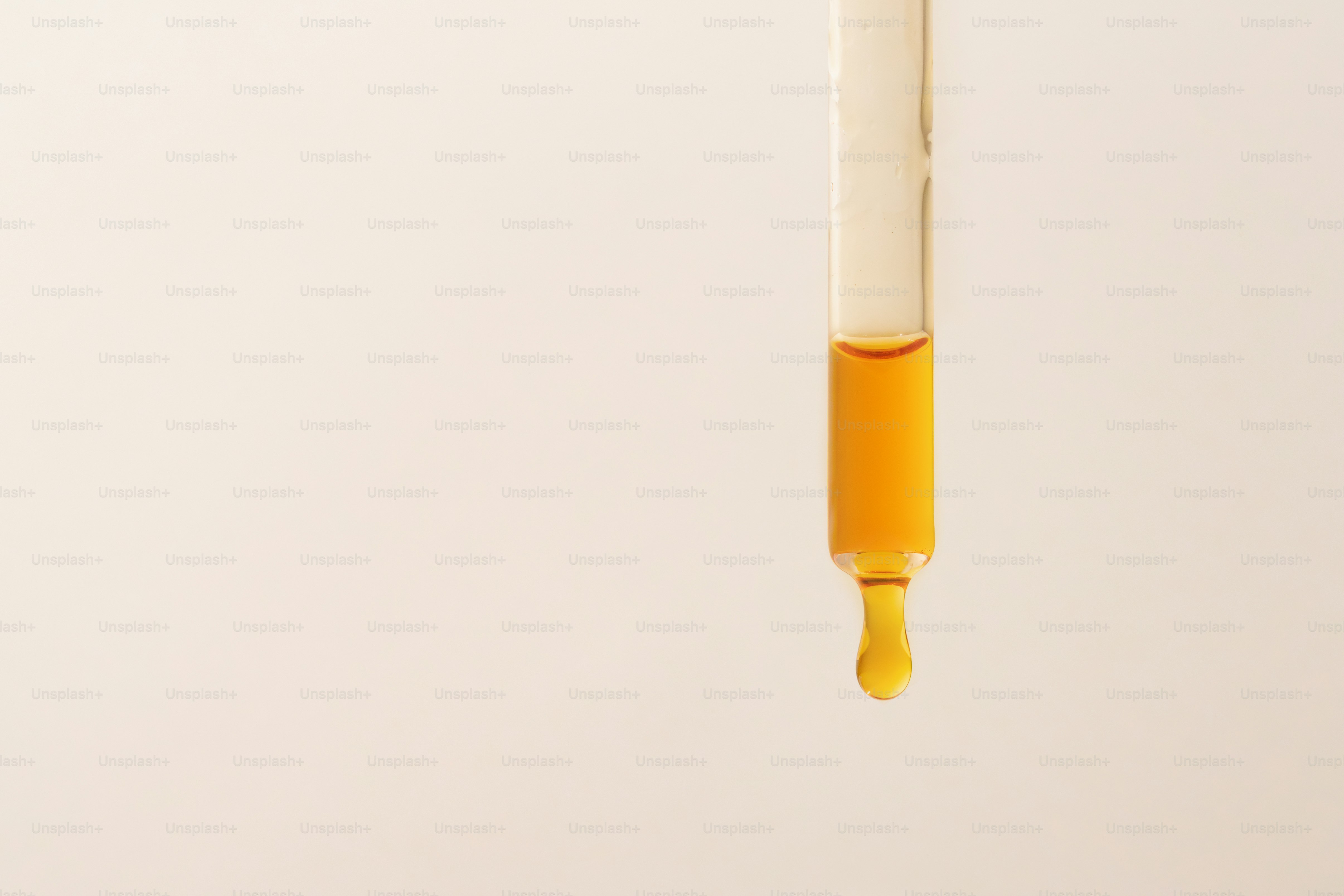 A dropper with amber liquid.