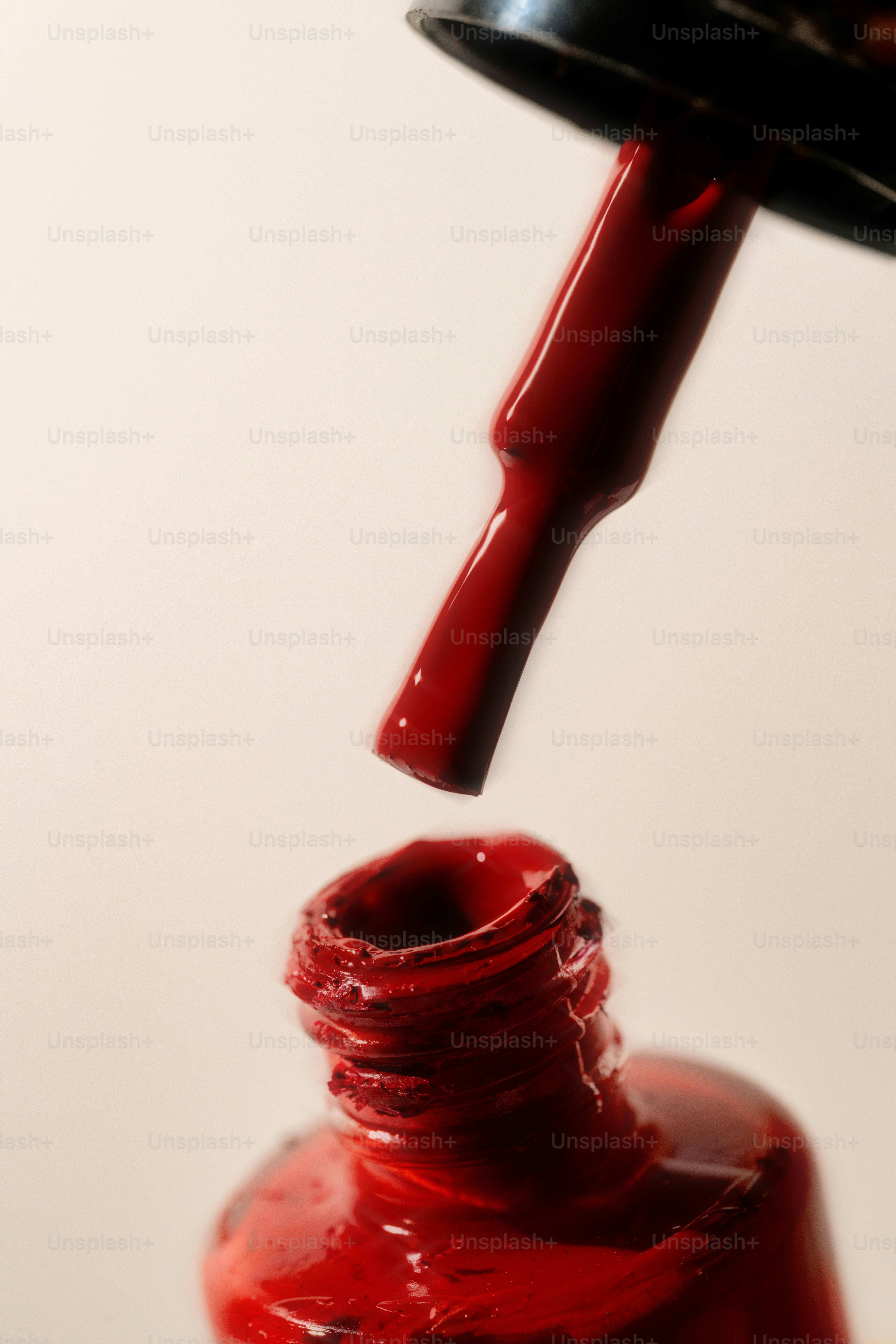 Red nail polish and brush are visible.