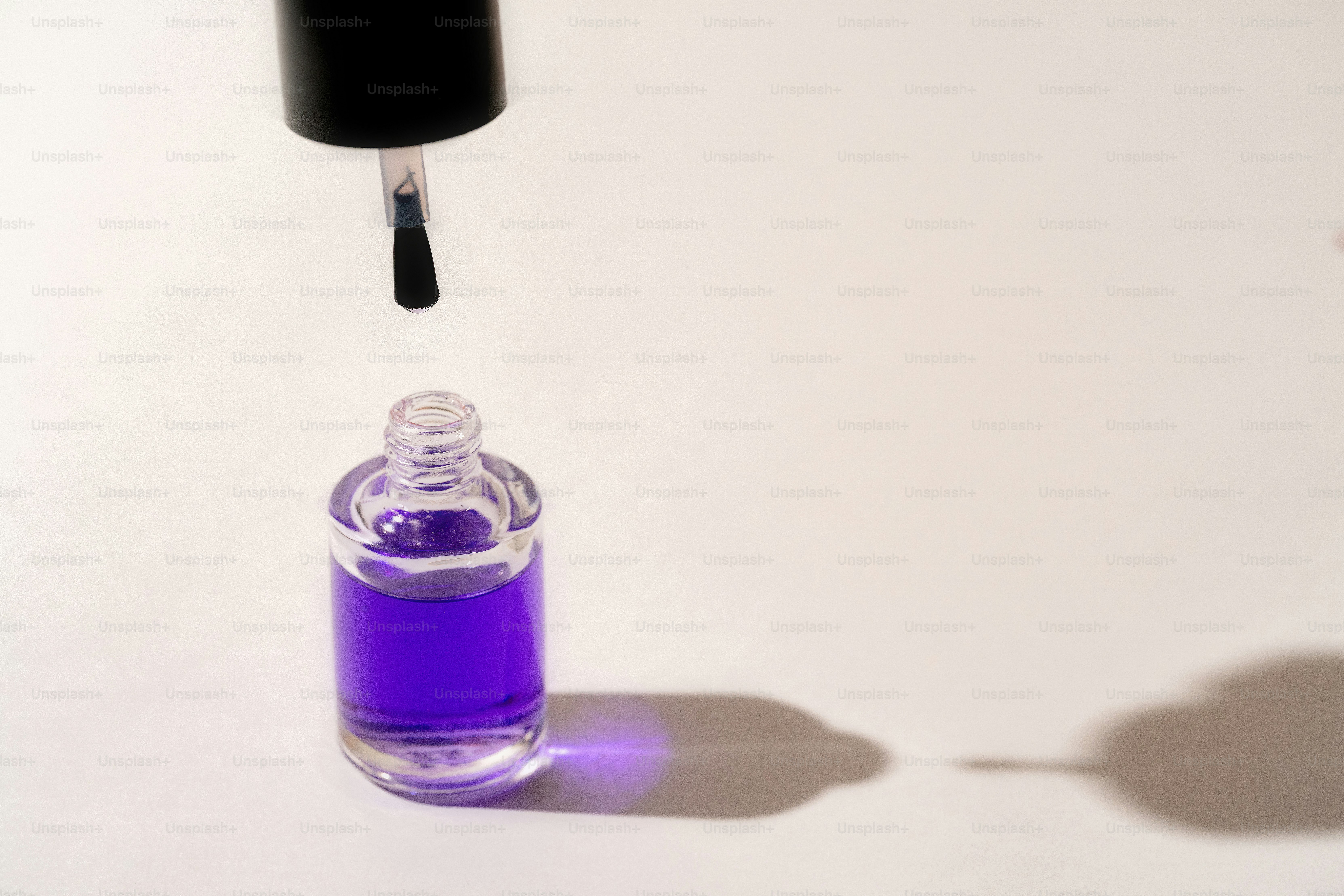 Nail polish bottle with brush poised above.