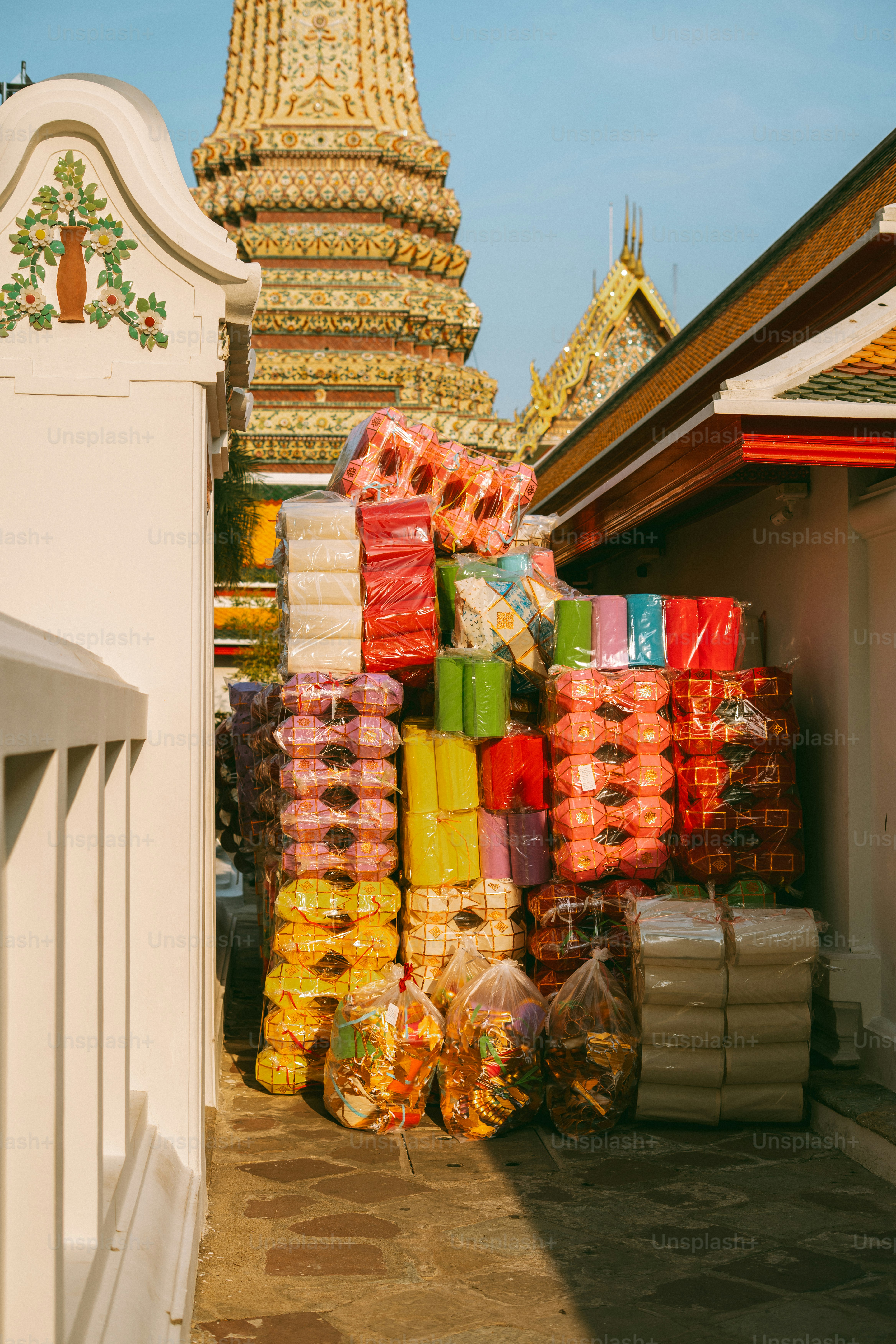 Colorful goods are stacked near a buddhist temple.
