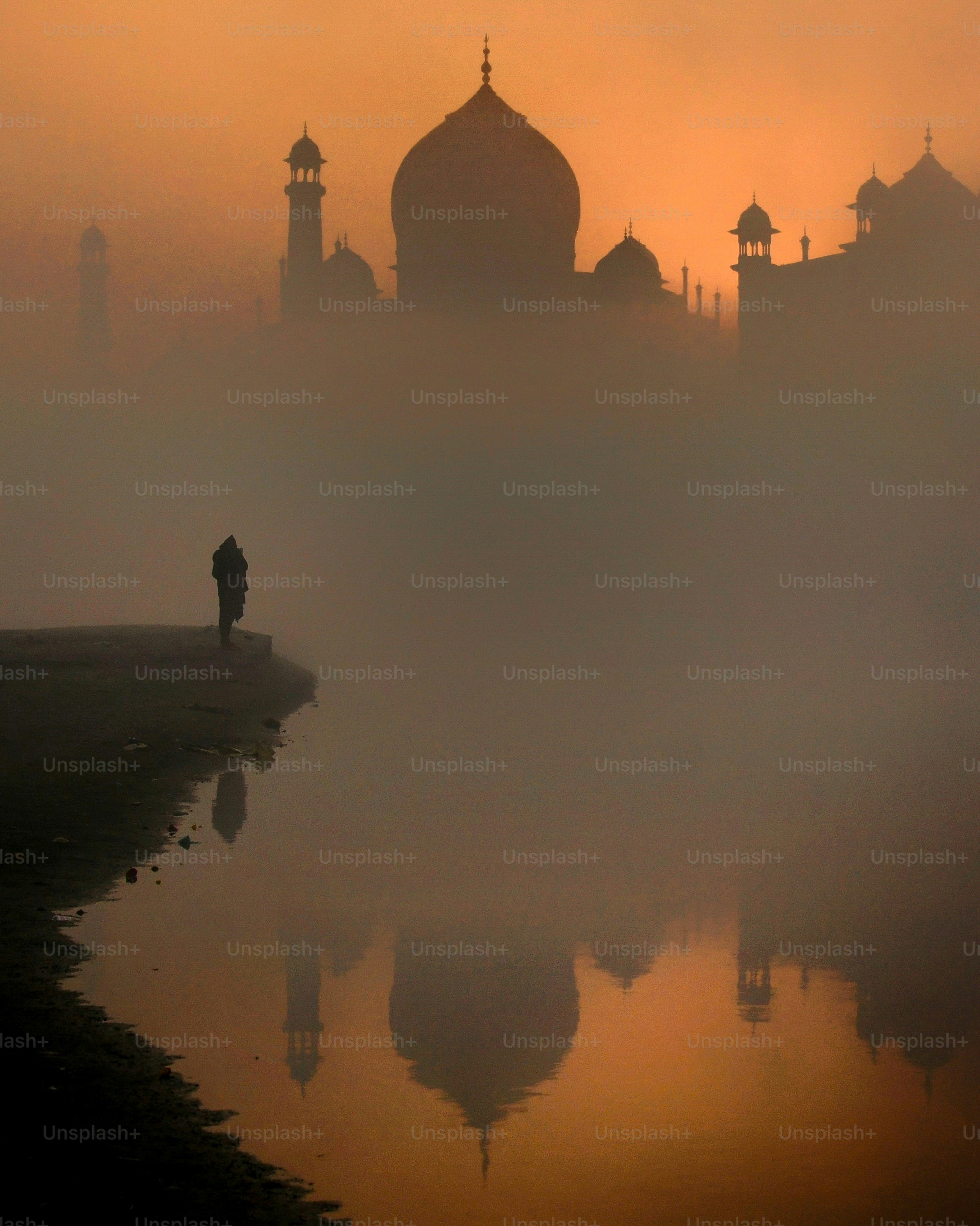 The taj mahal is shrouded in a misty sunrise.