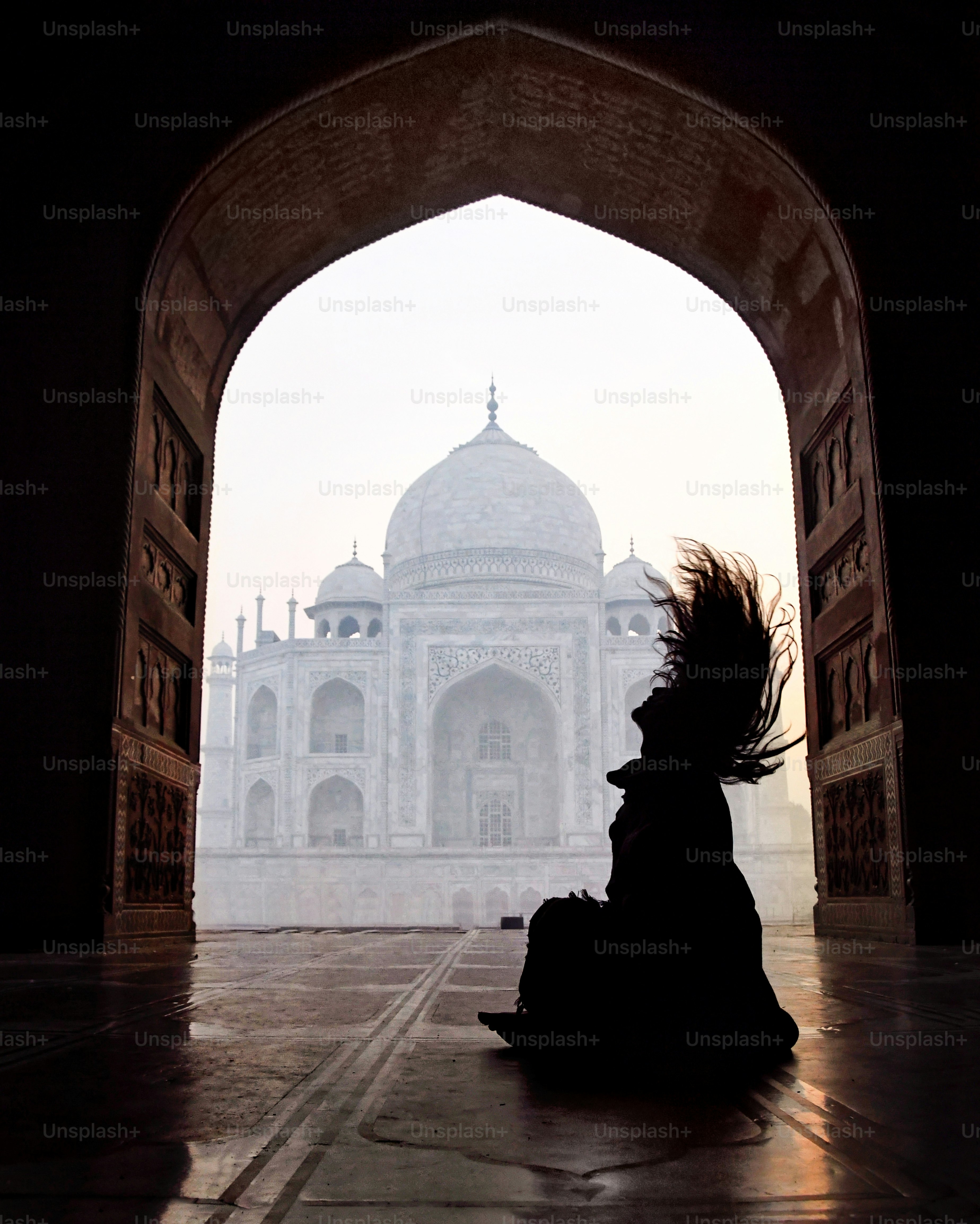 A silhouette poses in front of the taj mahal.