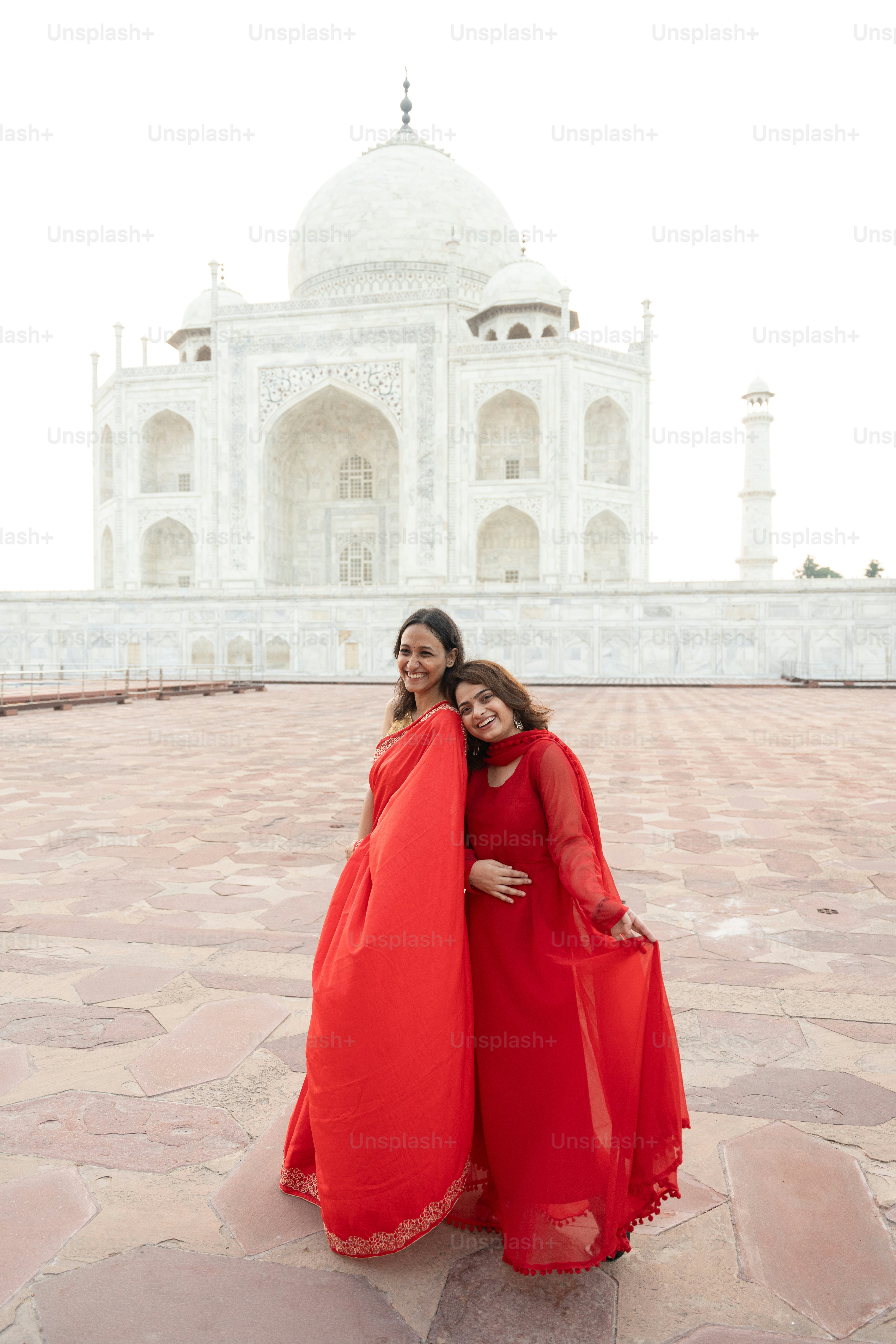 Dos mujeres posan frente al taj mahal.