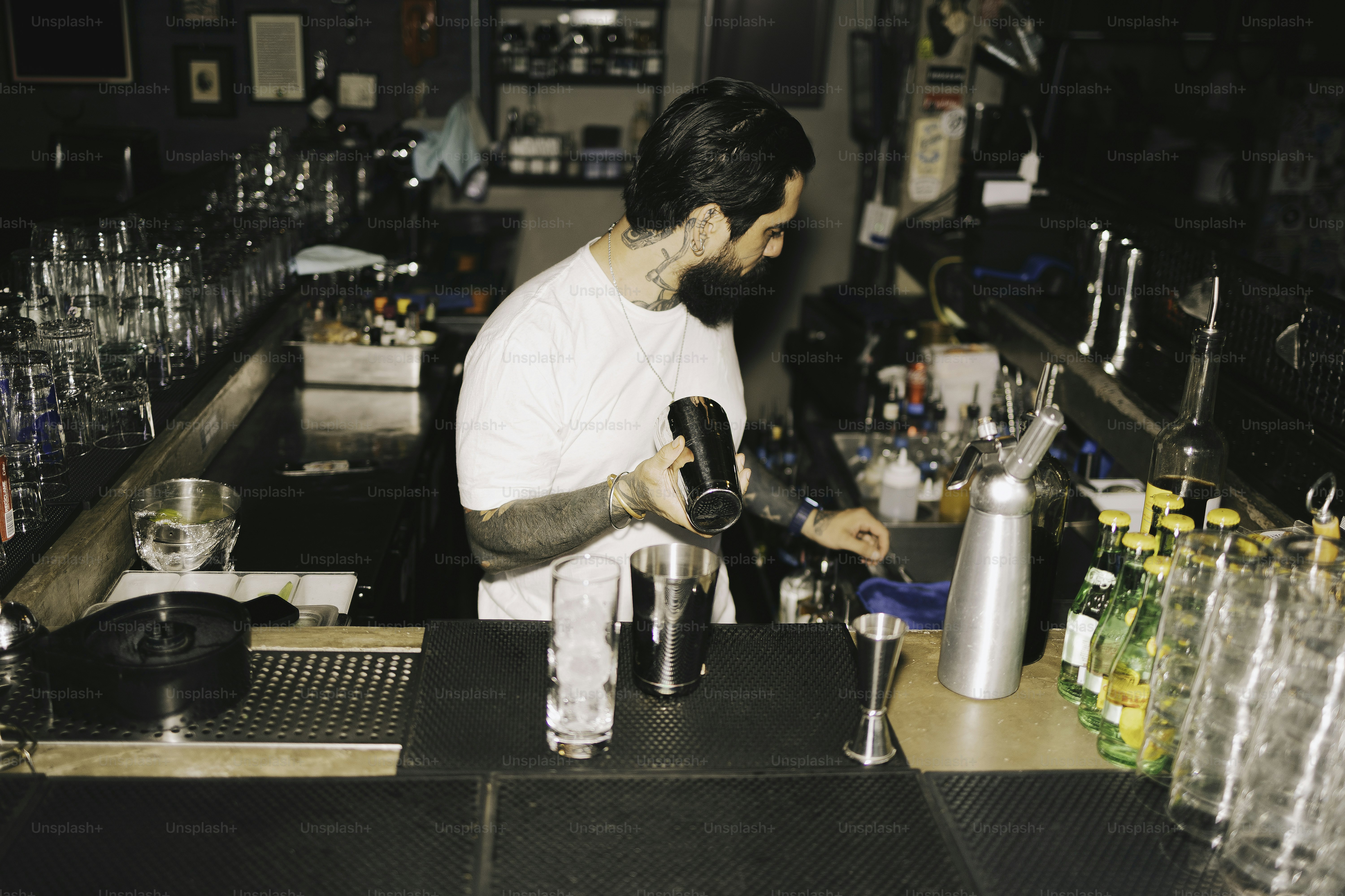 A bartender makes a cocktail behind the bar.