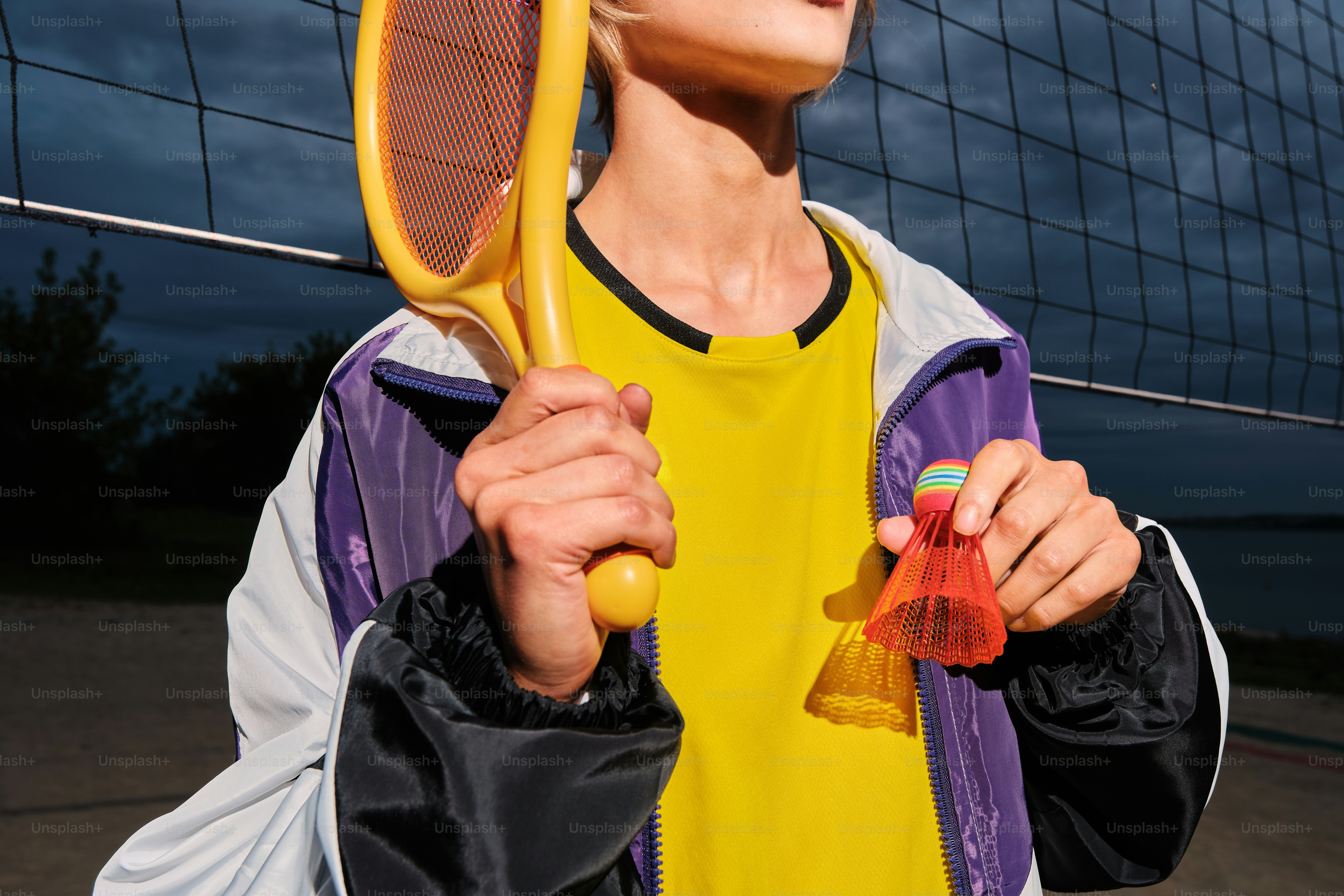 Una persona sostiene una raqueta y un volante.