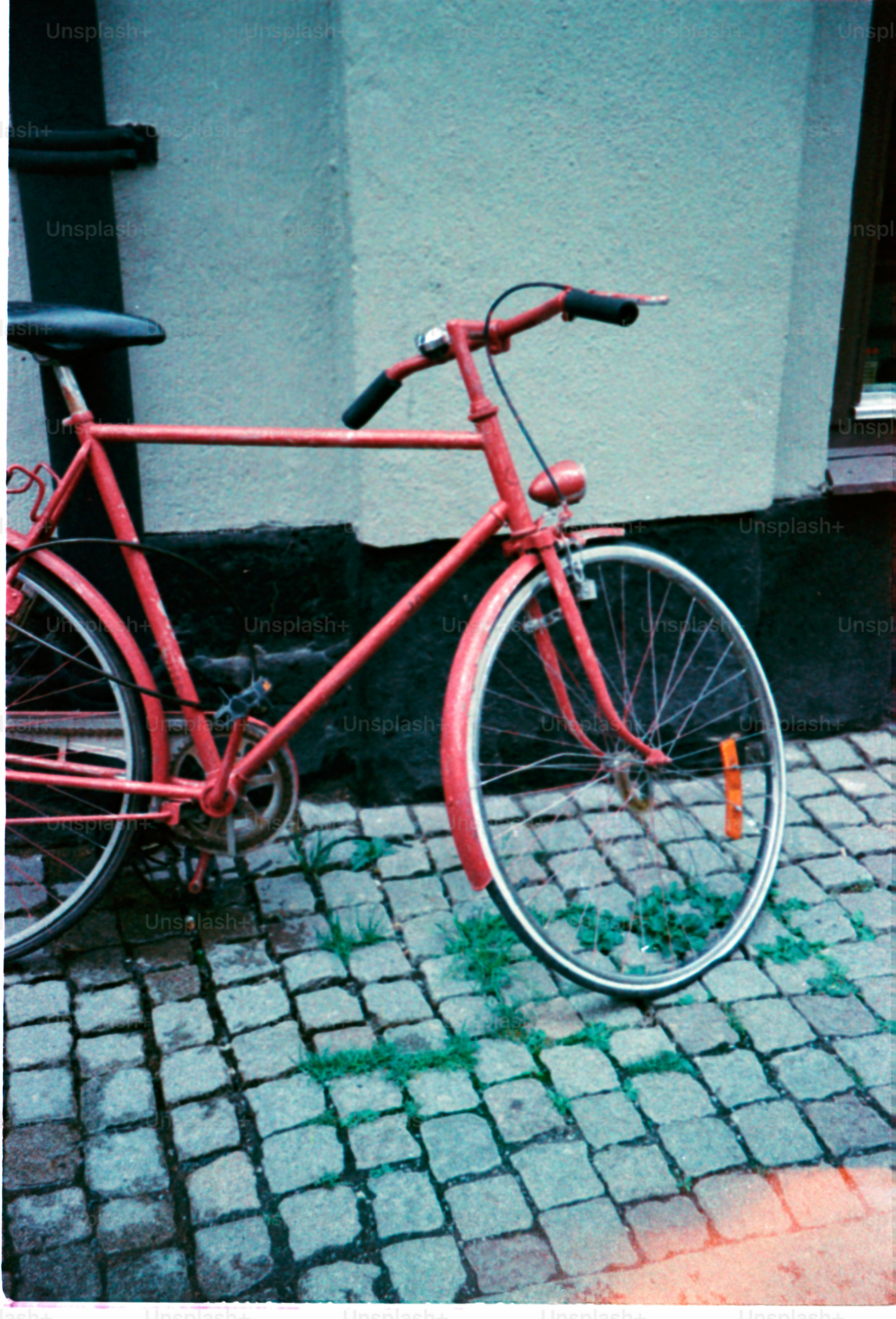 Ein rotes Fahrrad lehnt an einer Wand.