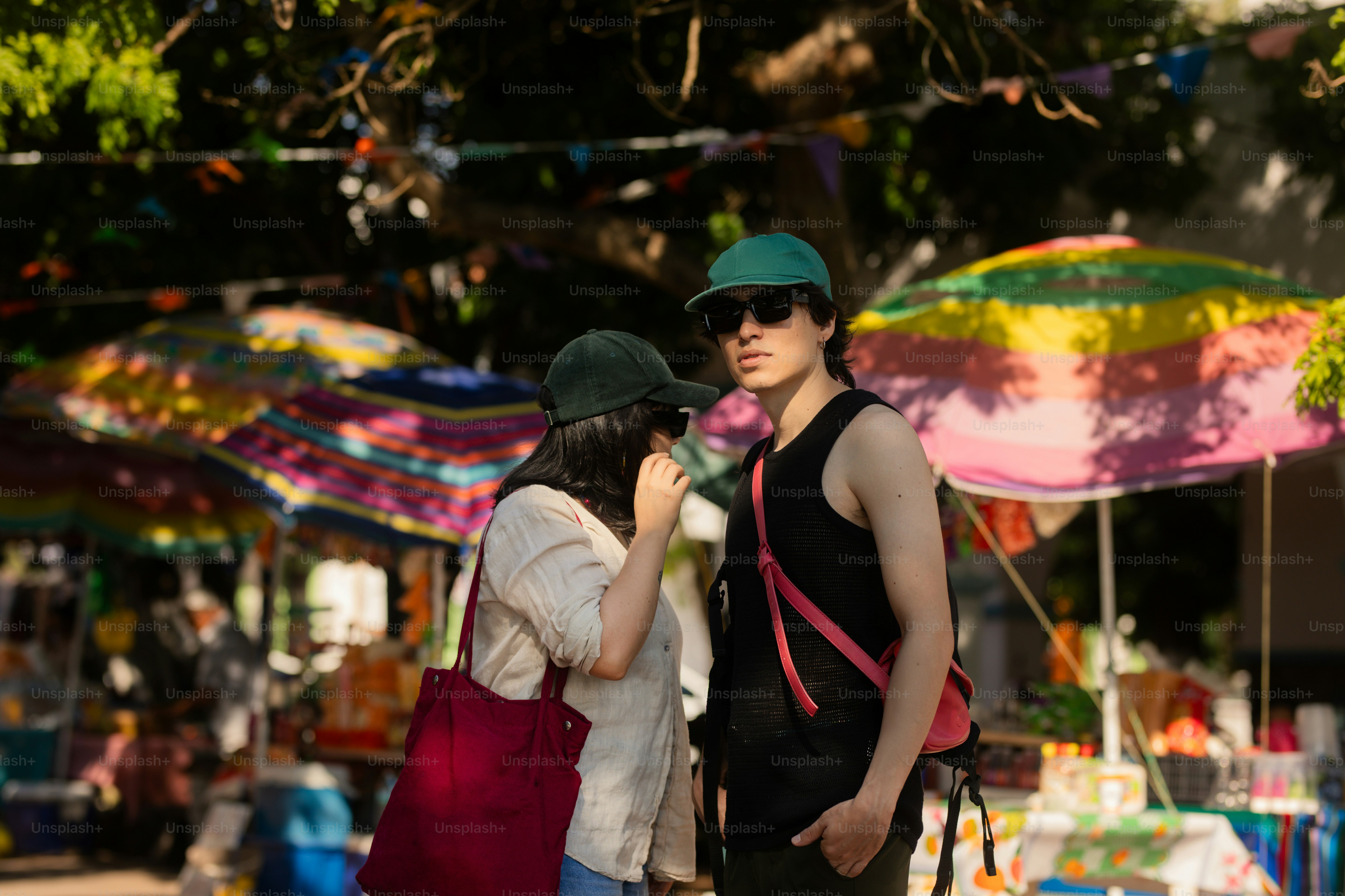 Dos personas se paran en un concurrido mercado al aire libre.