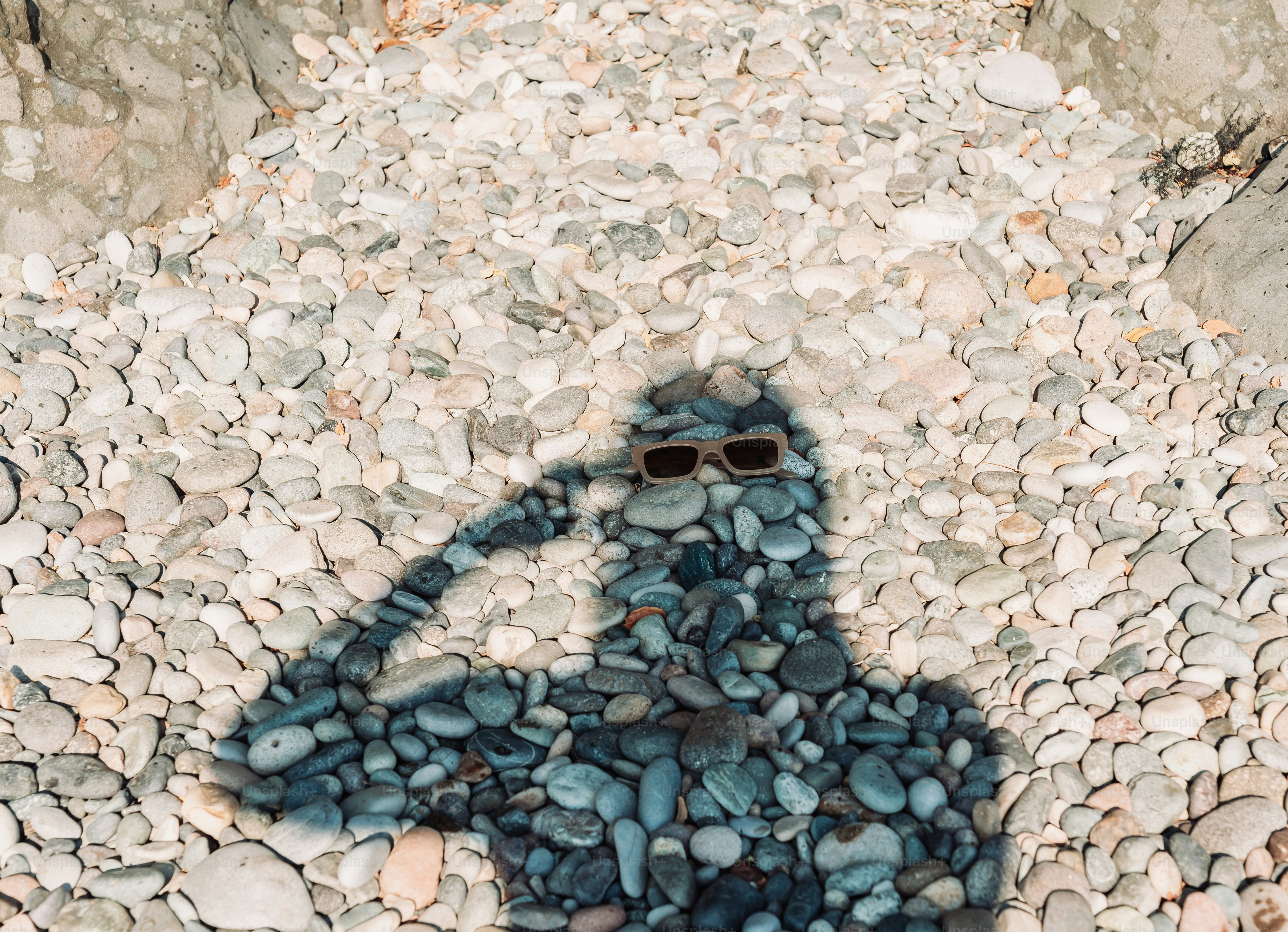 Sombra de uma pessoa saudando, em terreno rochoso.