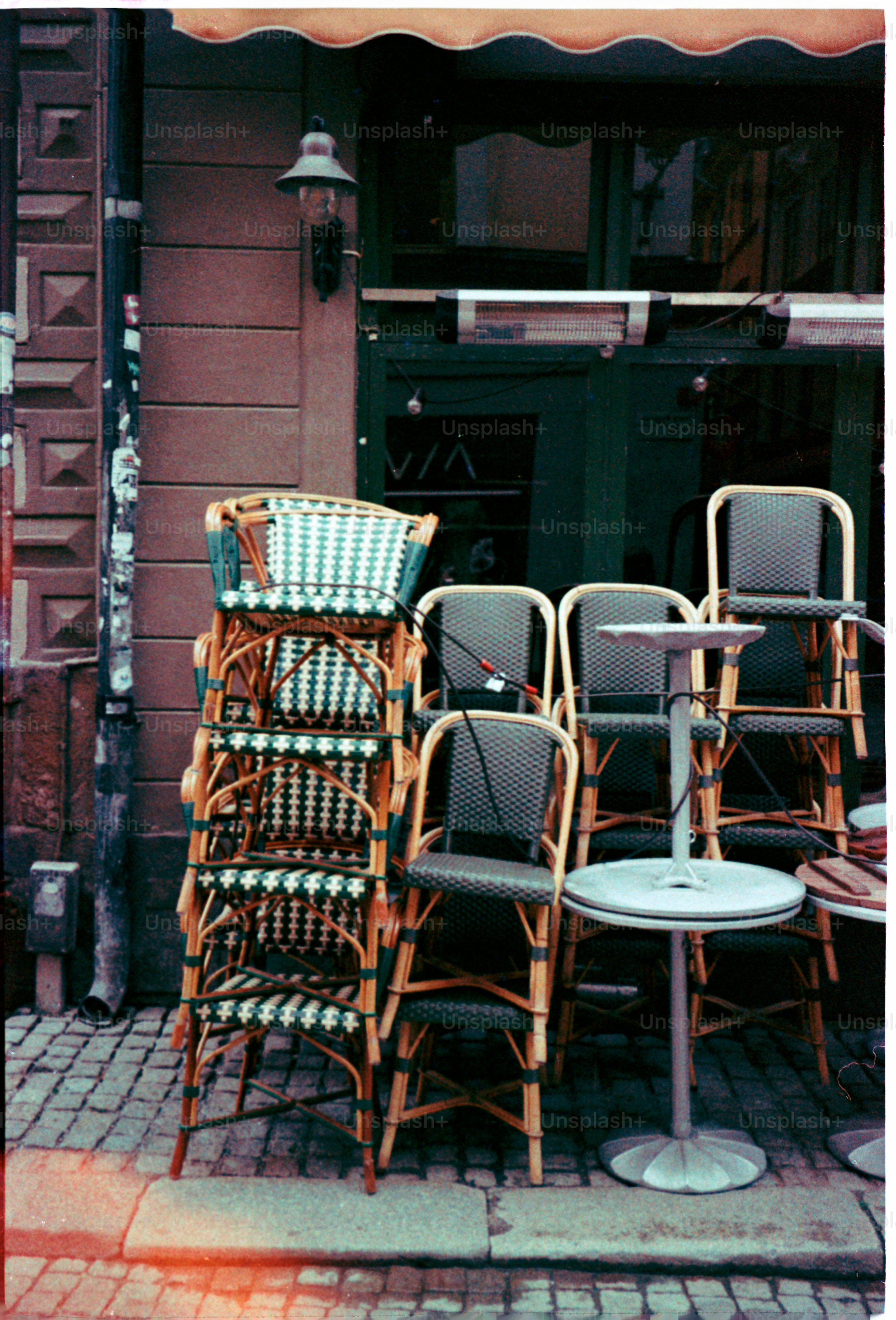 Chairs and tables stacked outside a cafe.