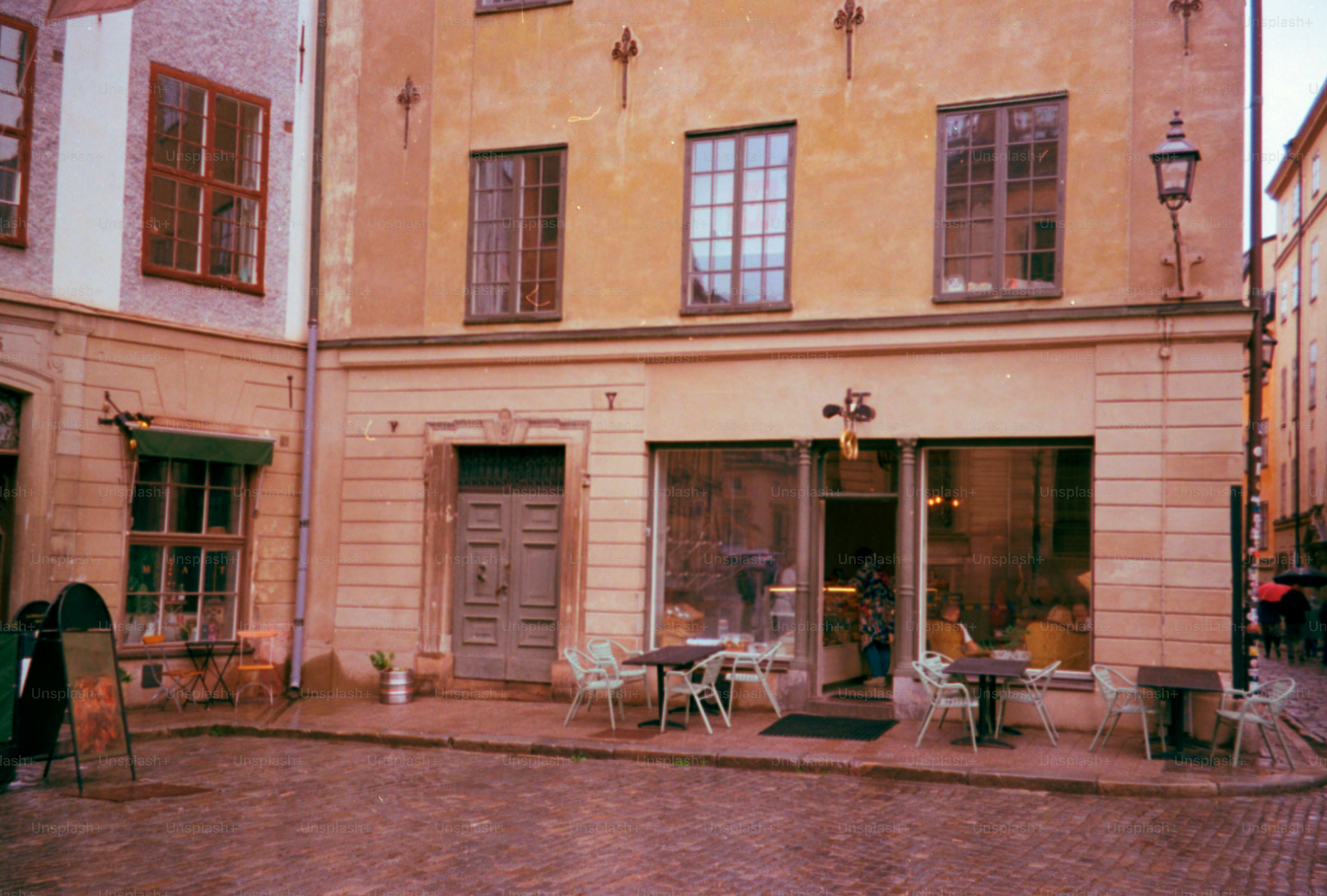 An old european cafe sits on a cobblestone street.