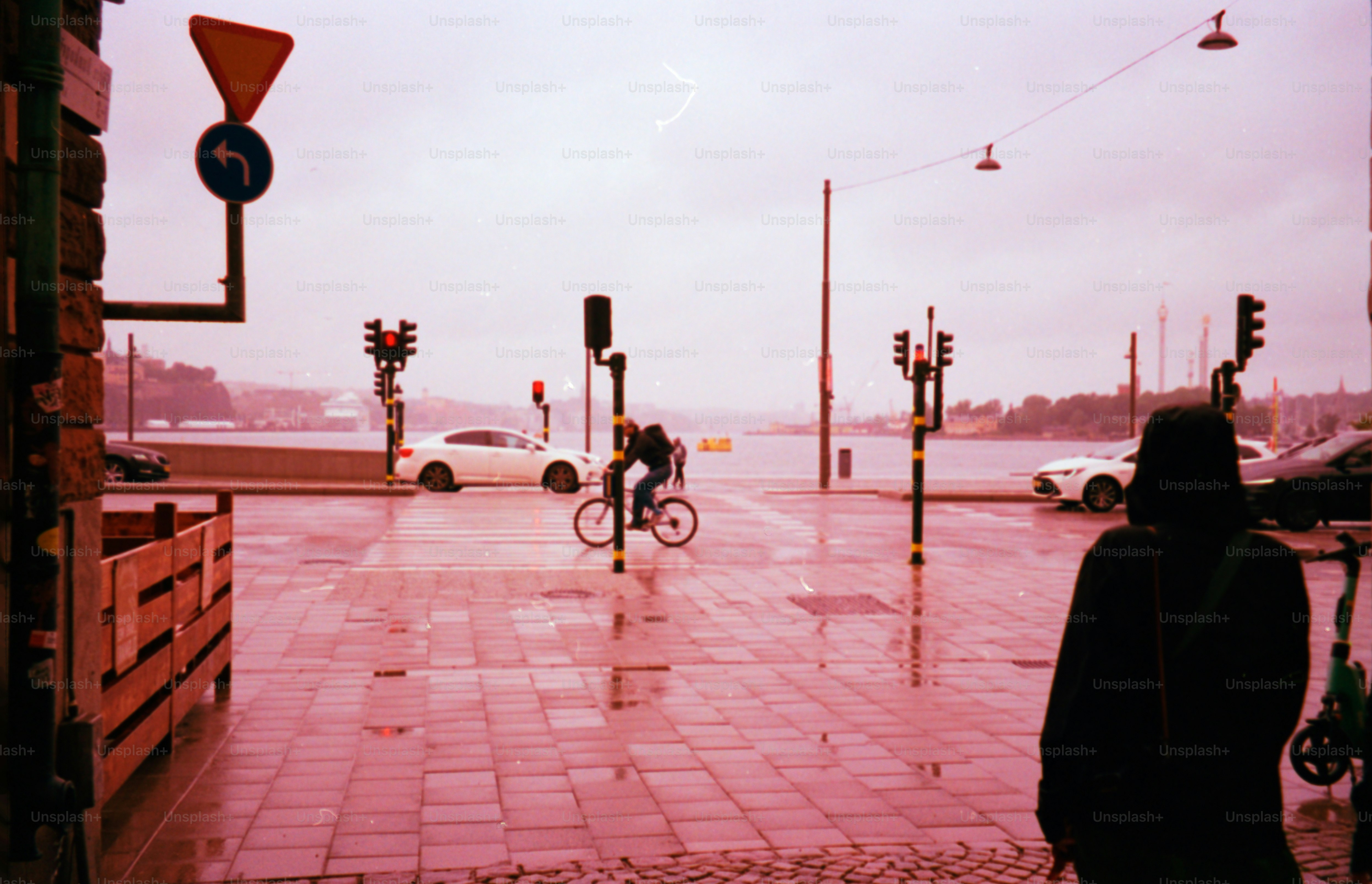 Rainy day scene with traffic and pedestrian.