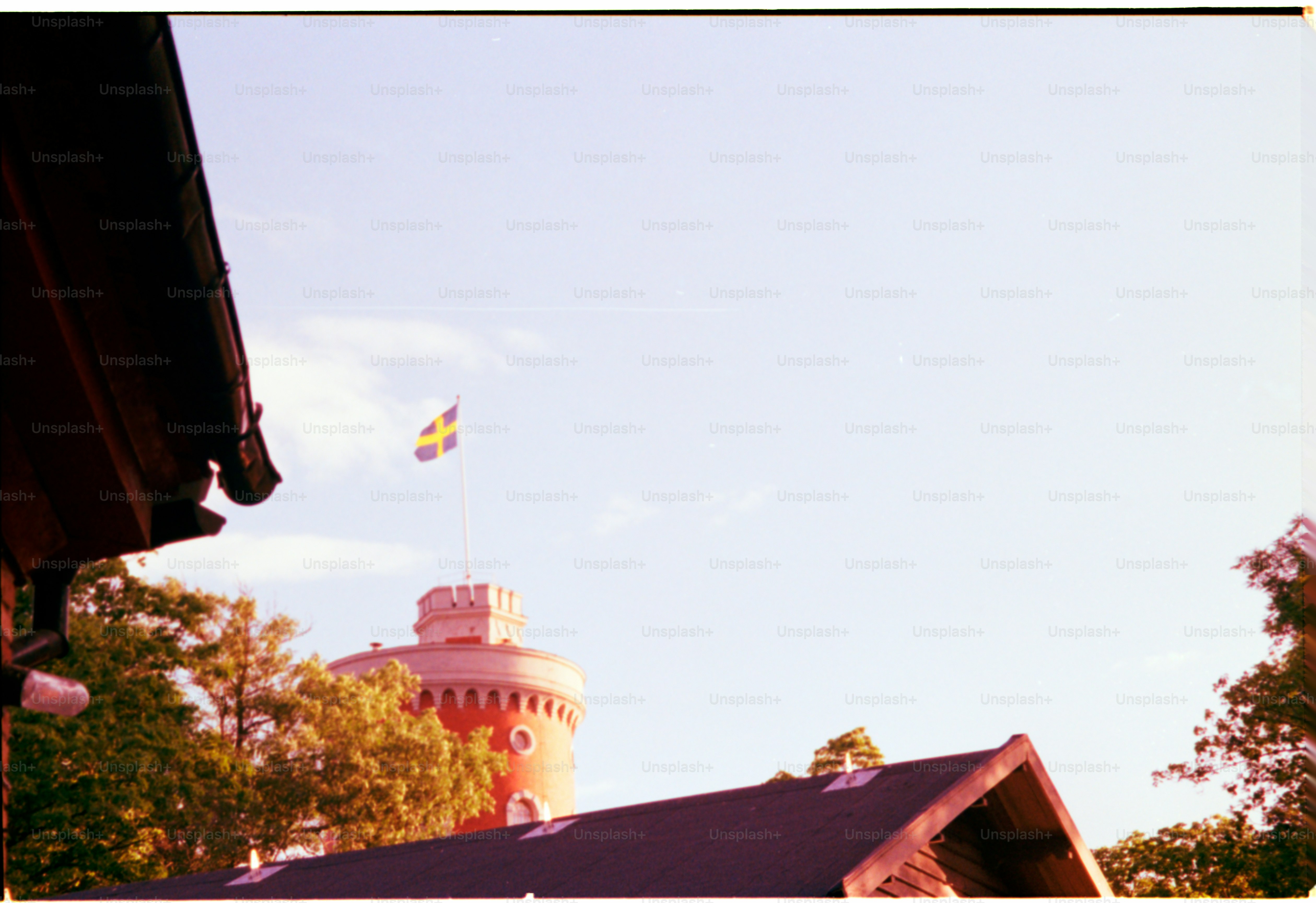 A swedish flag flies above a building.