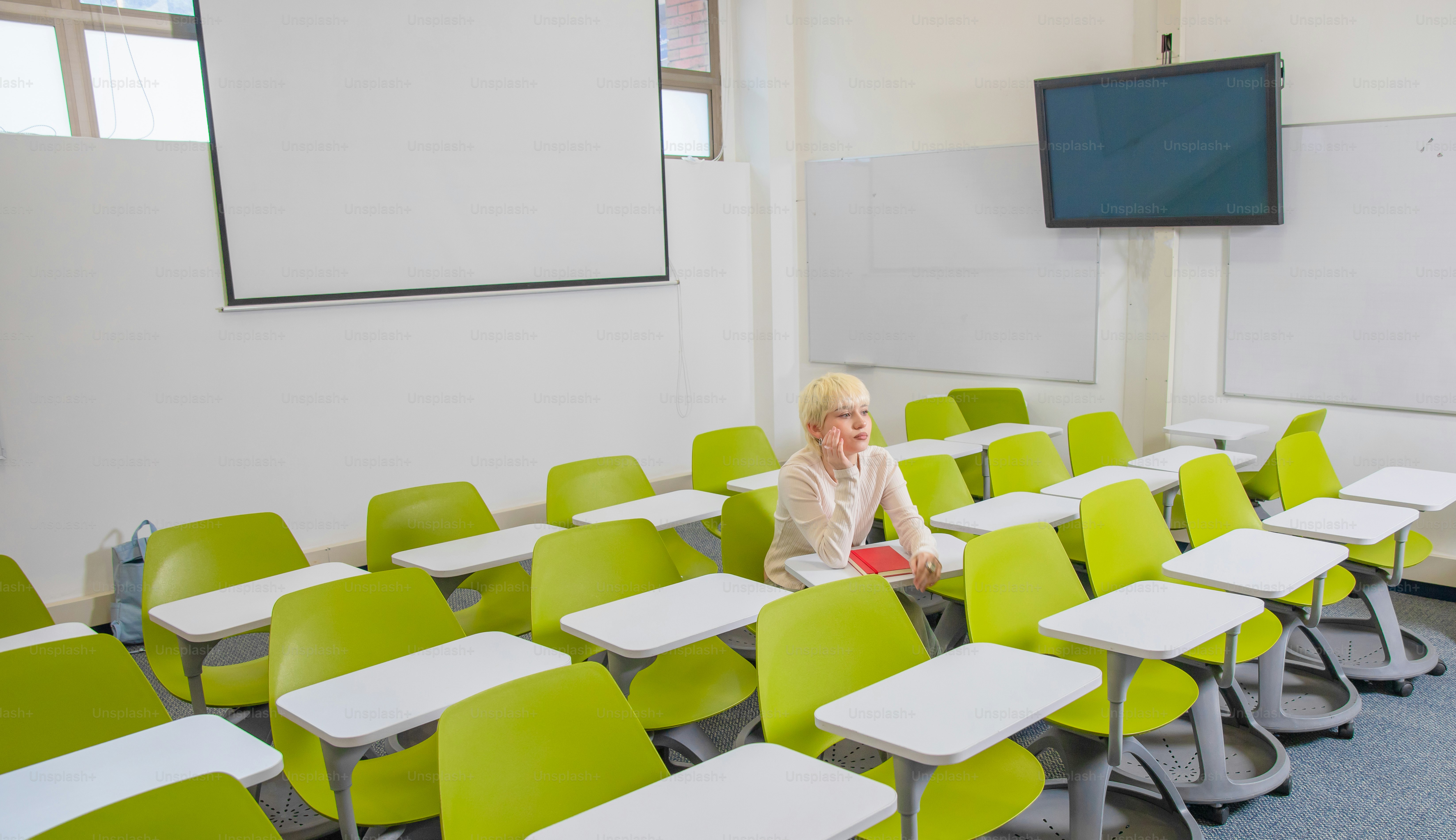 A professor sits alone in an empty classroom.