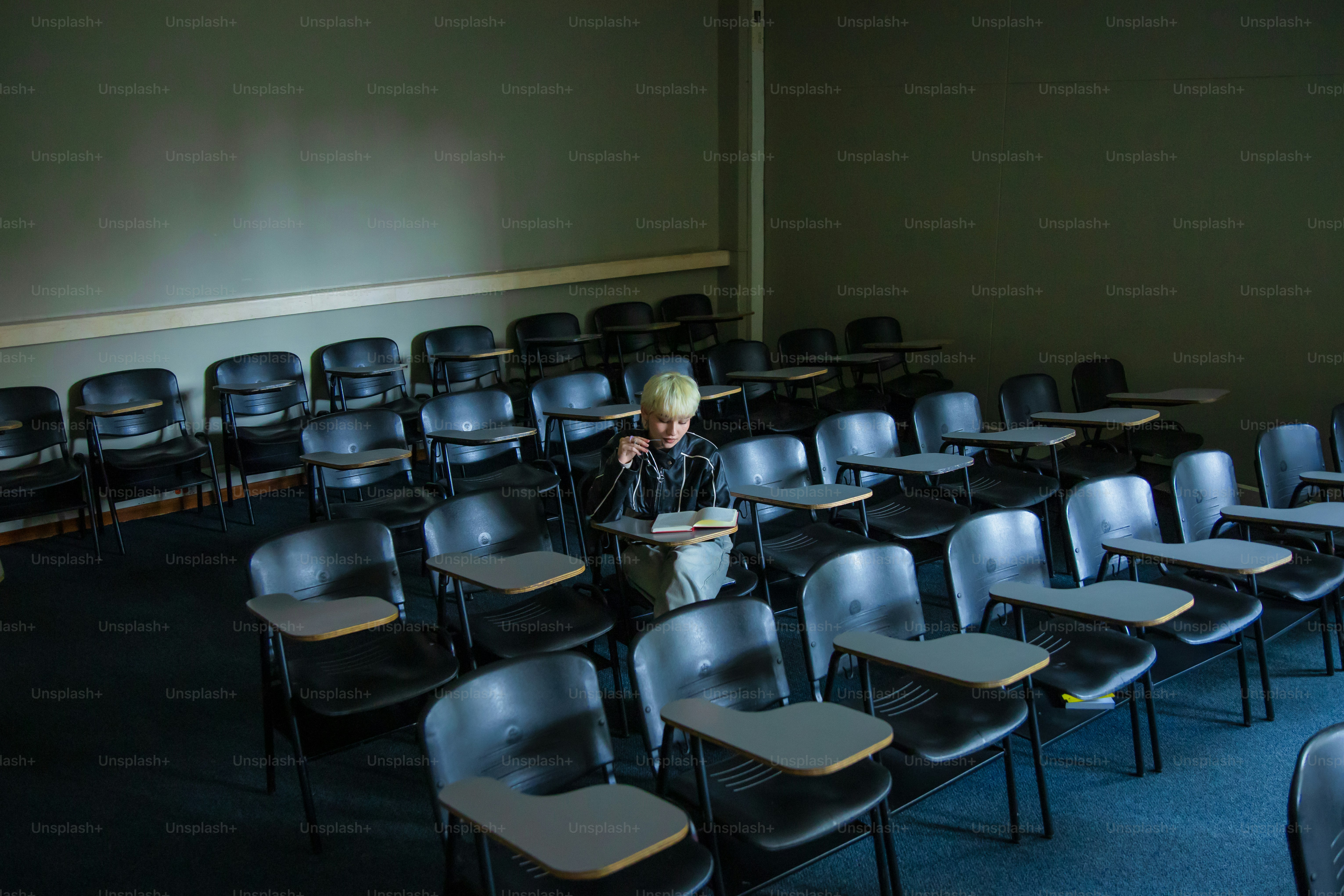 A student reads in an empty classroom.