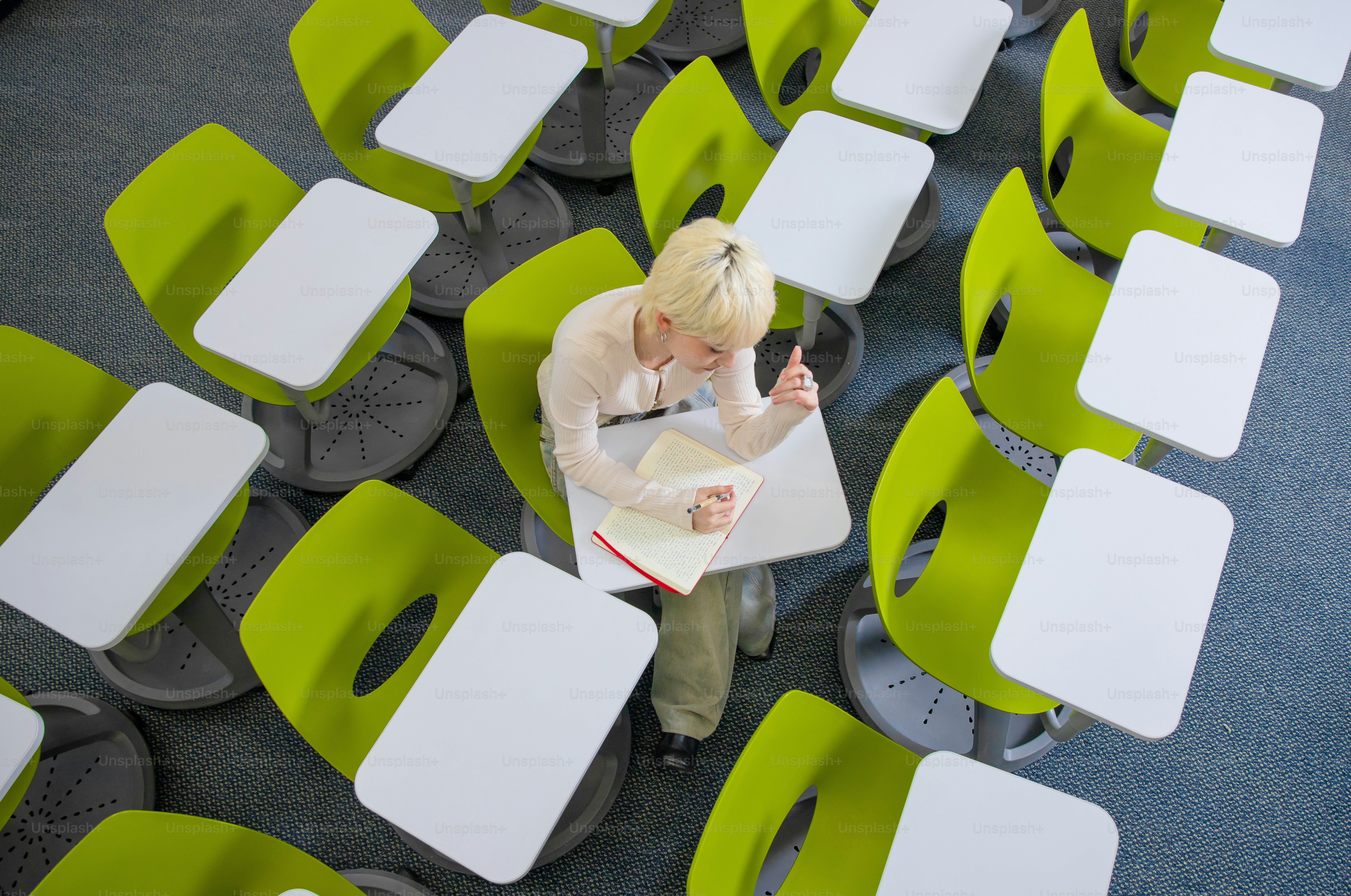 A student is in a classroom full of chairs.