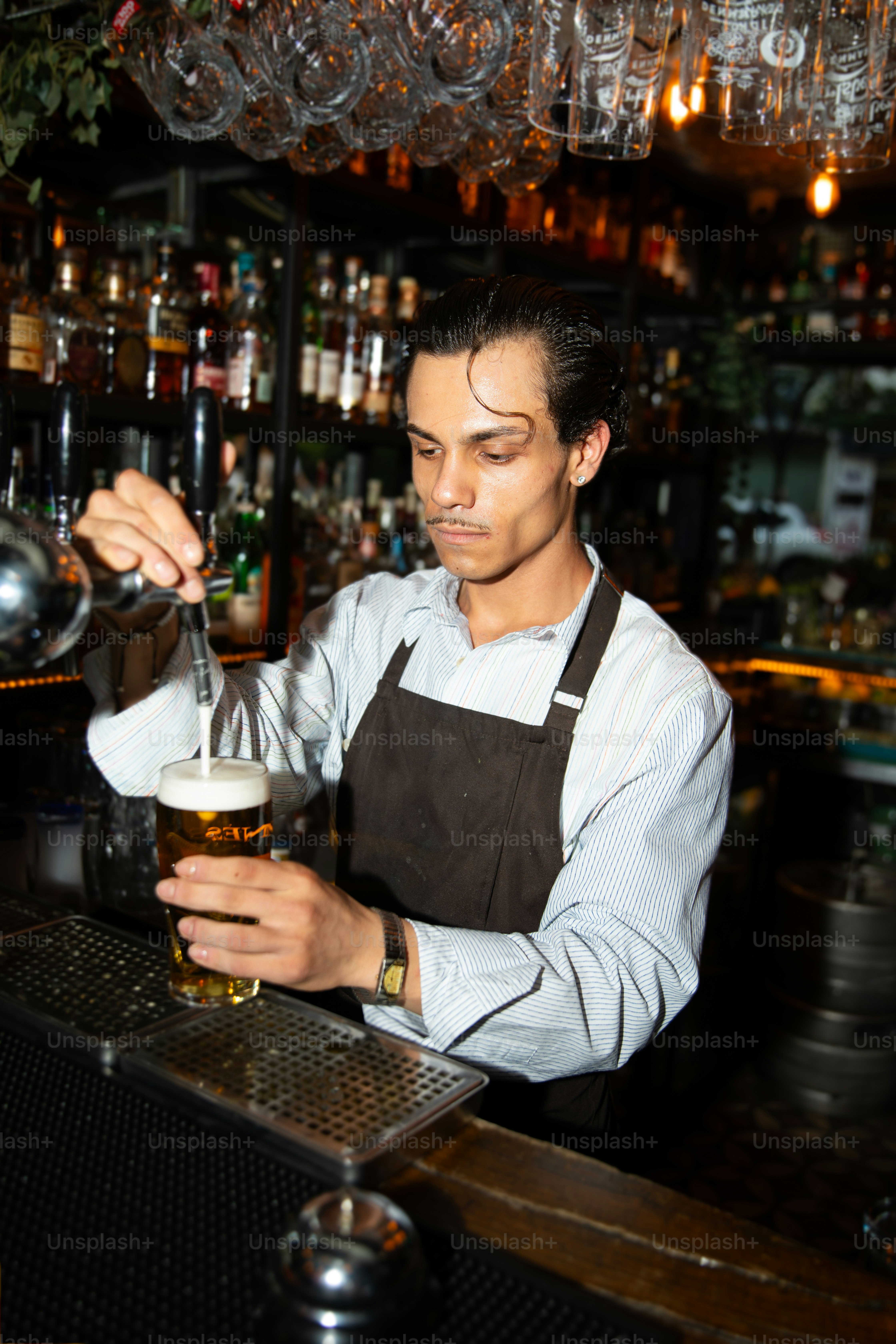 A bartender pours beer at a bar.