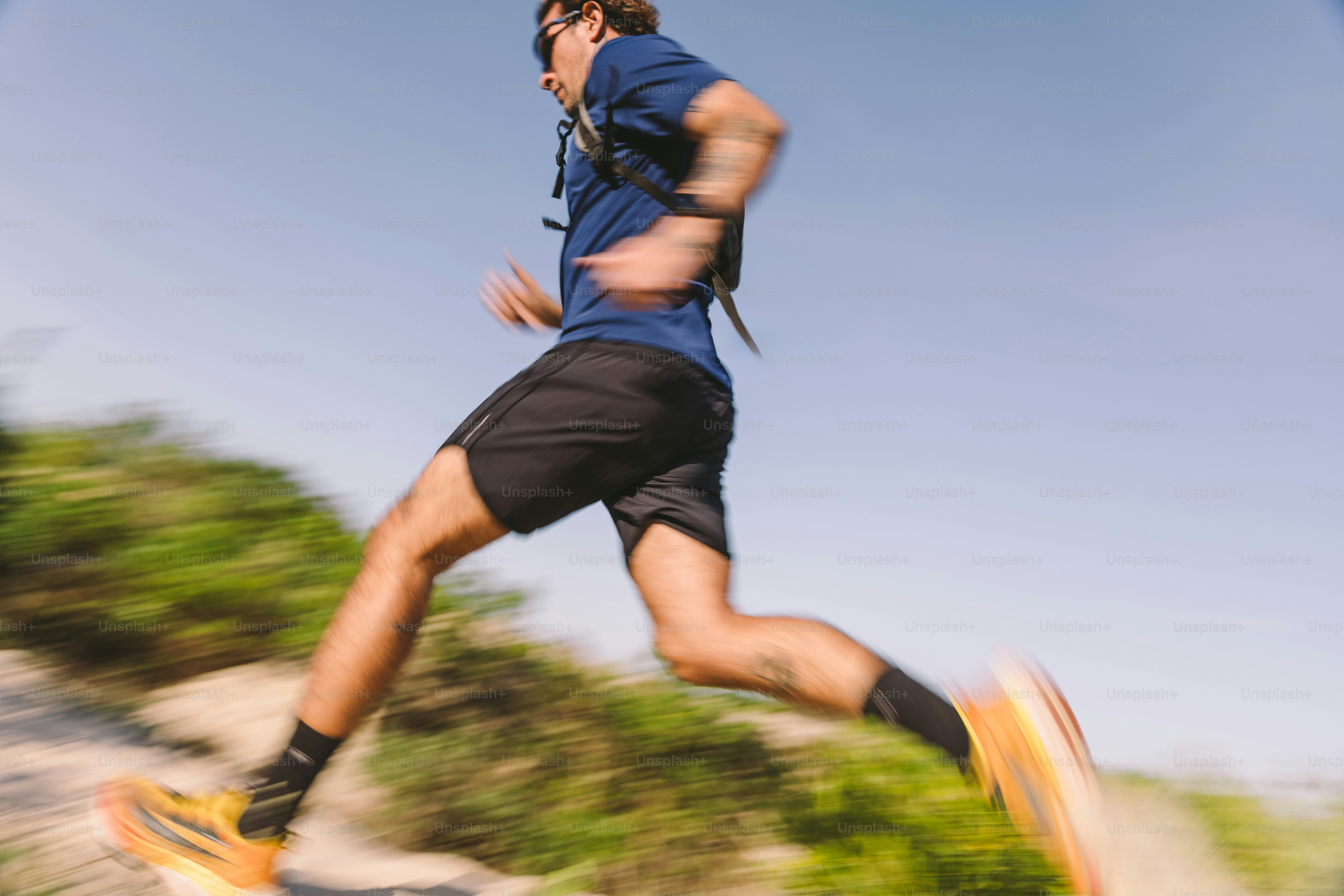 A man runs along a sunny trail.