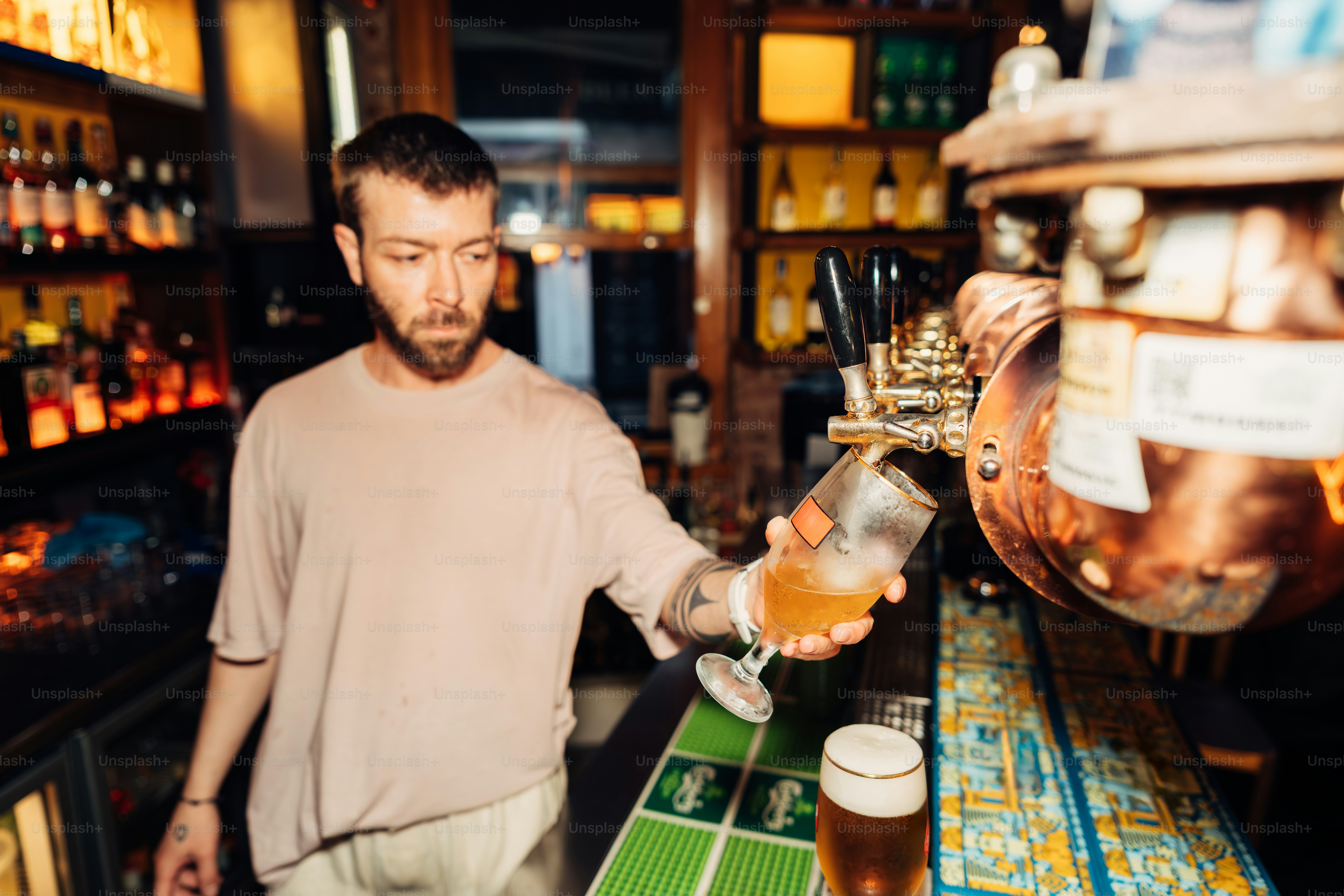 A bartender is pouring a beer in a bar.