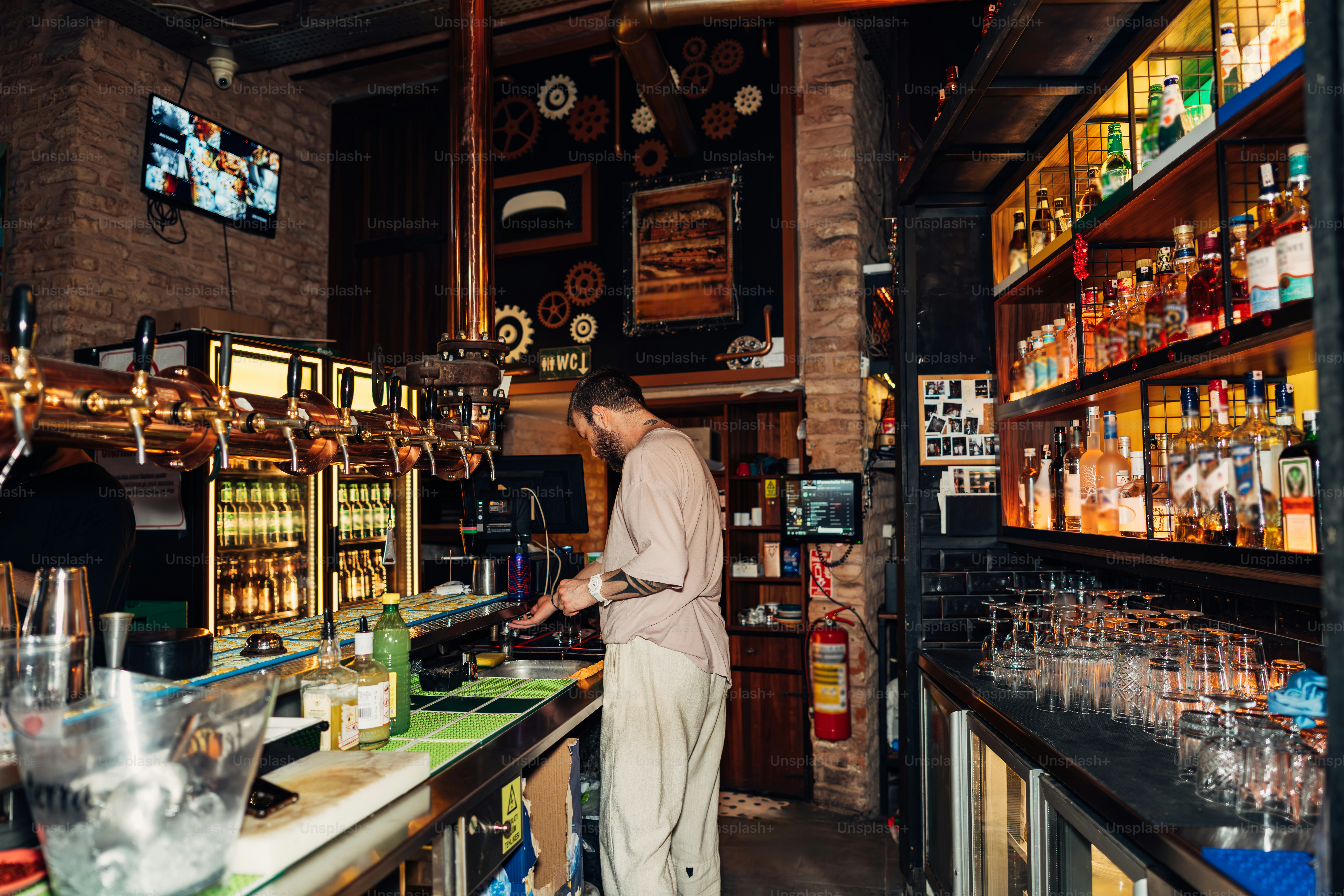 Ein Barkeeper arbeitet in einer rustikalen, gut sortierten Bar.