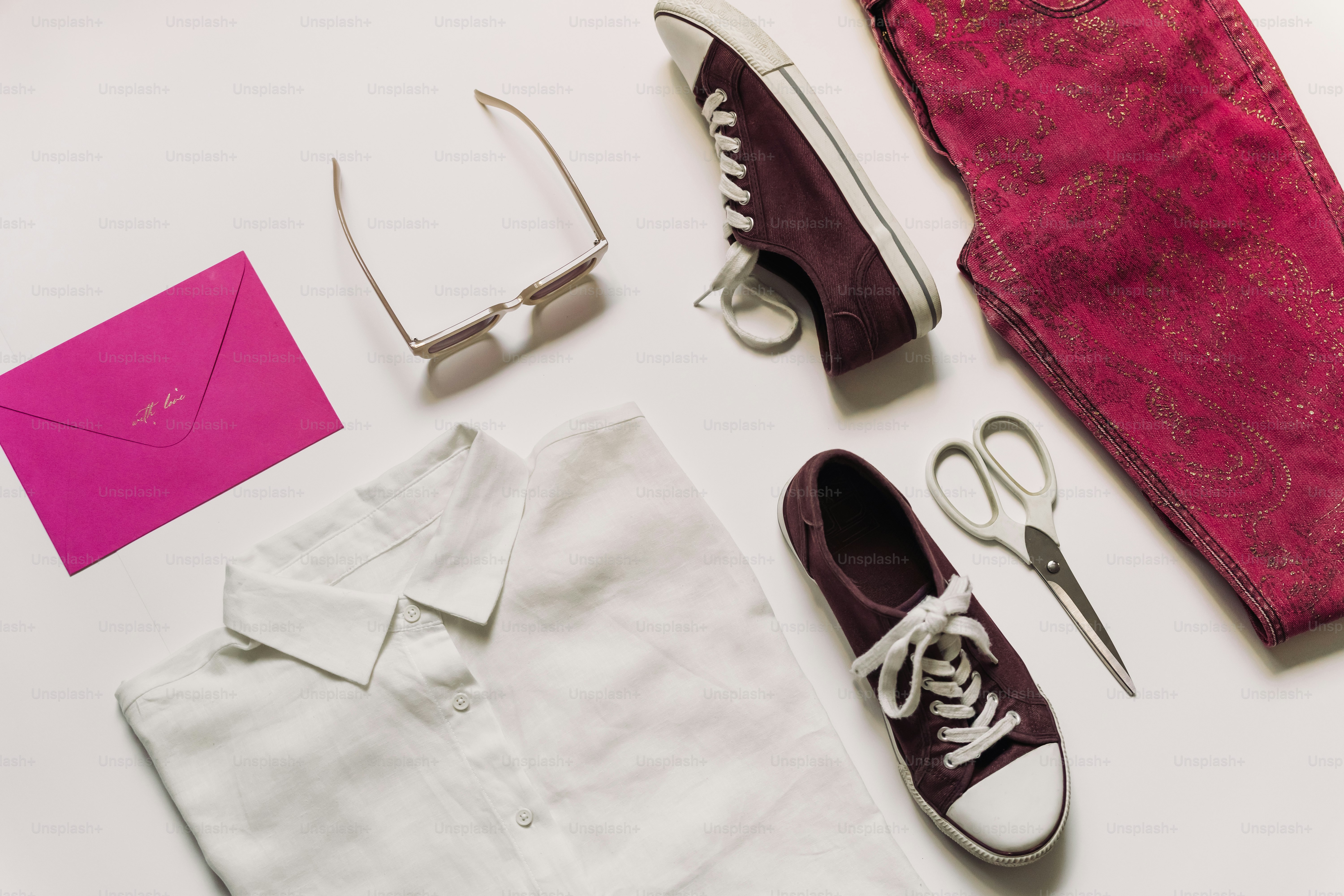 Clothing and accessories are arranged on a white surface.