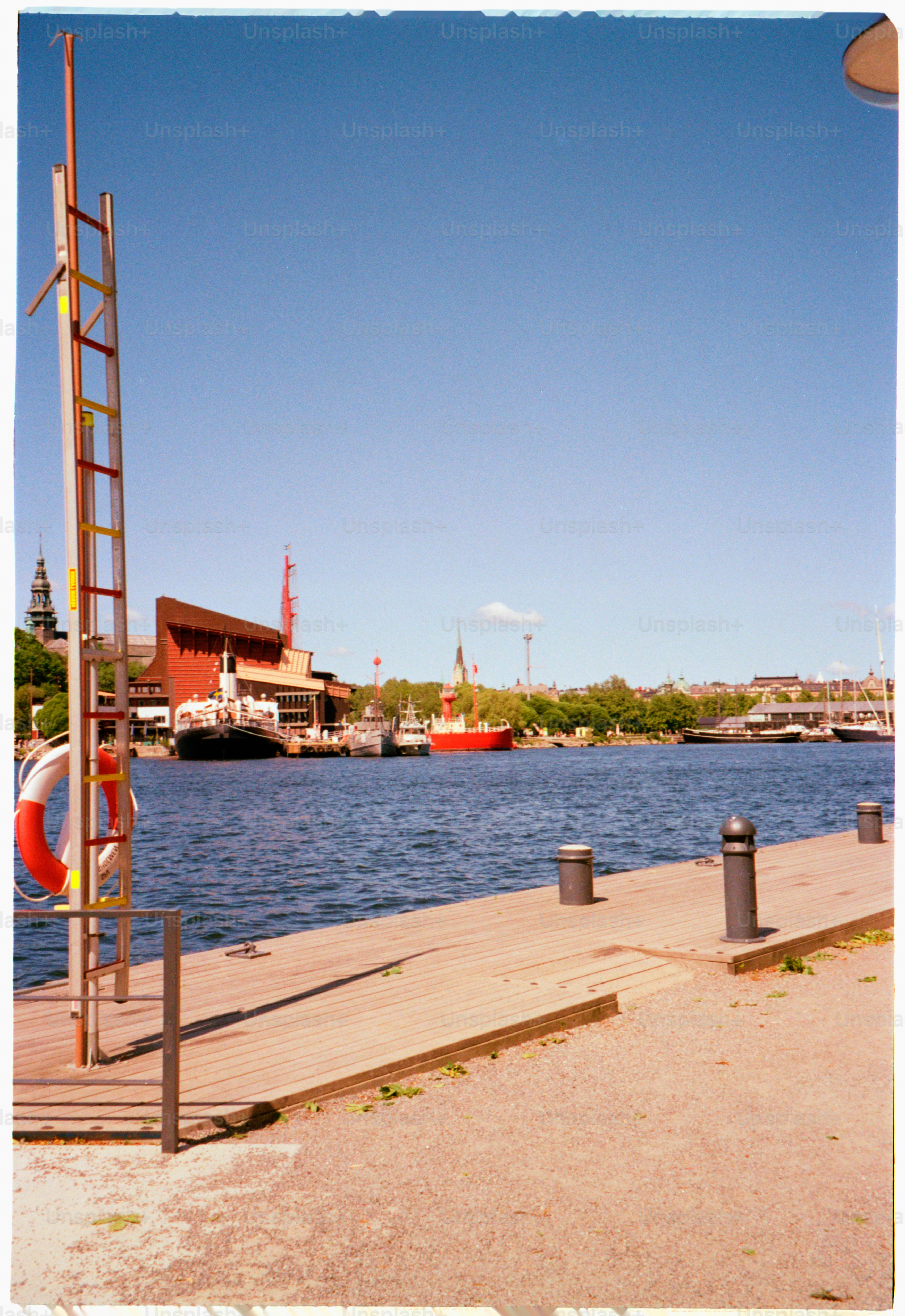 Waterfront view with boats under a clear blue sky.