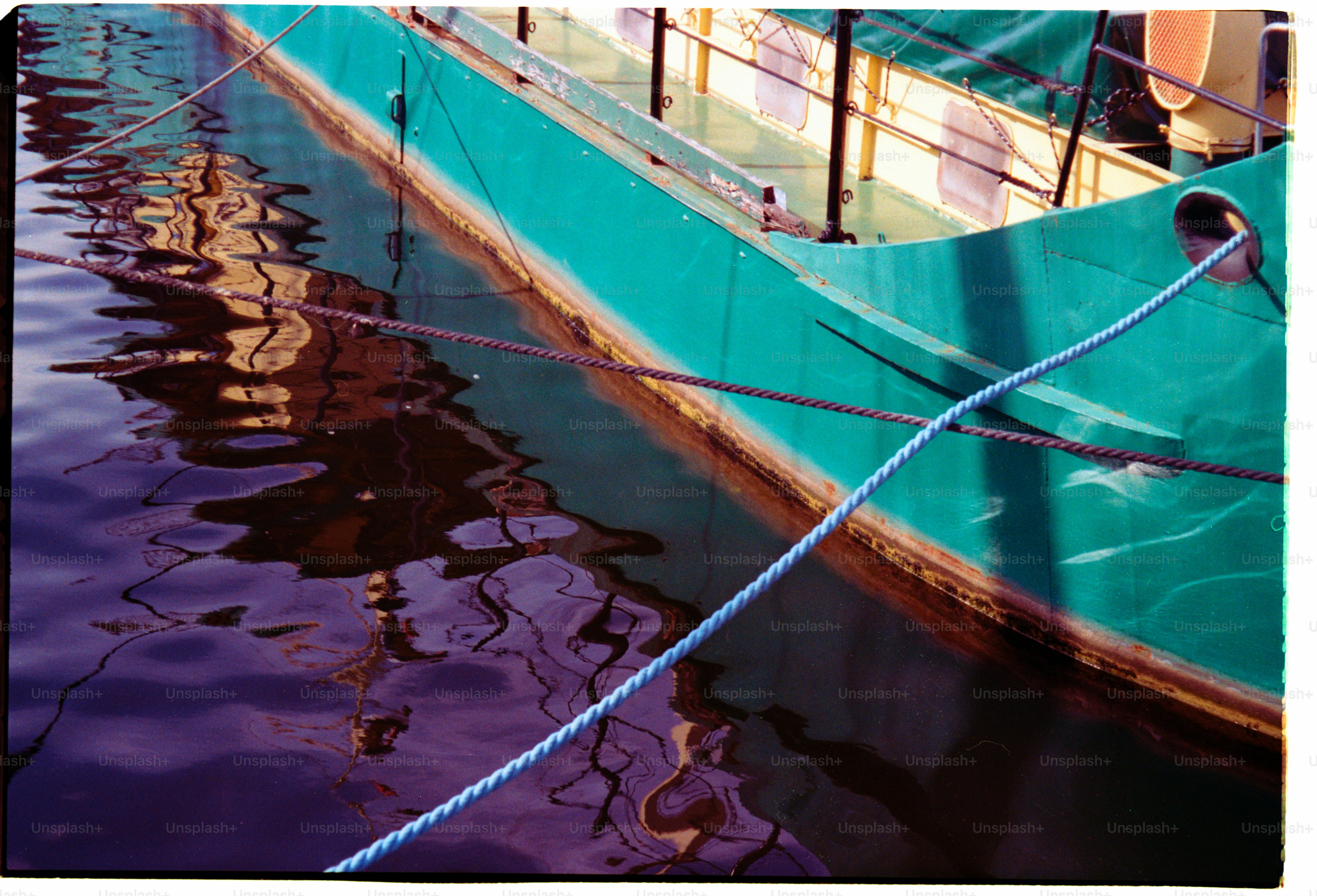 Ein türkisfarbenes Boot, das am Dock festgemacht hat.