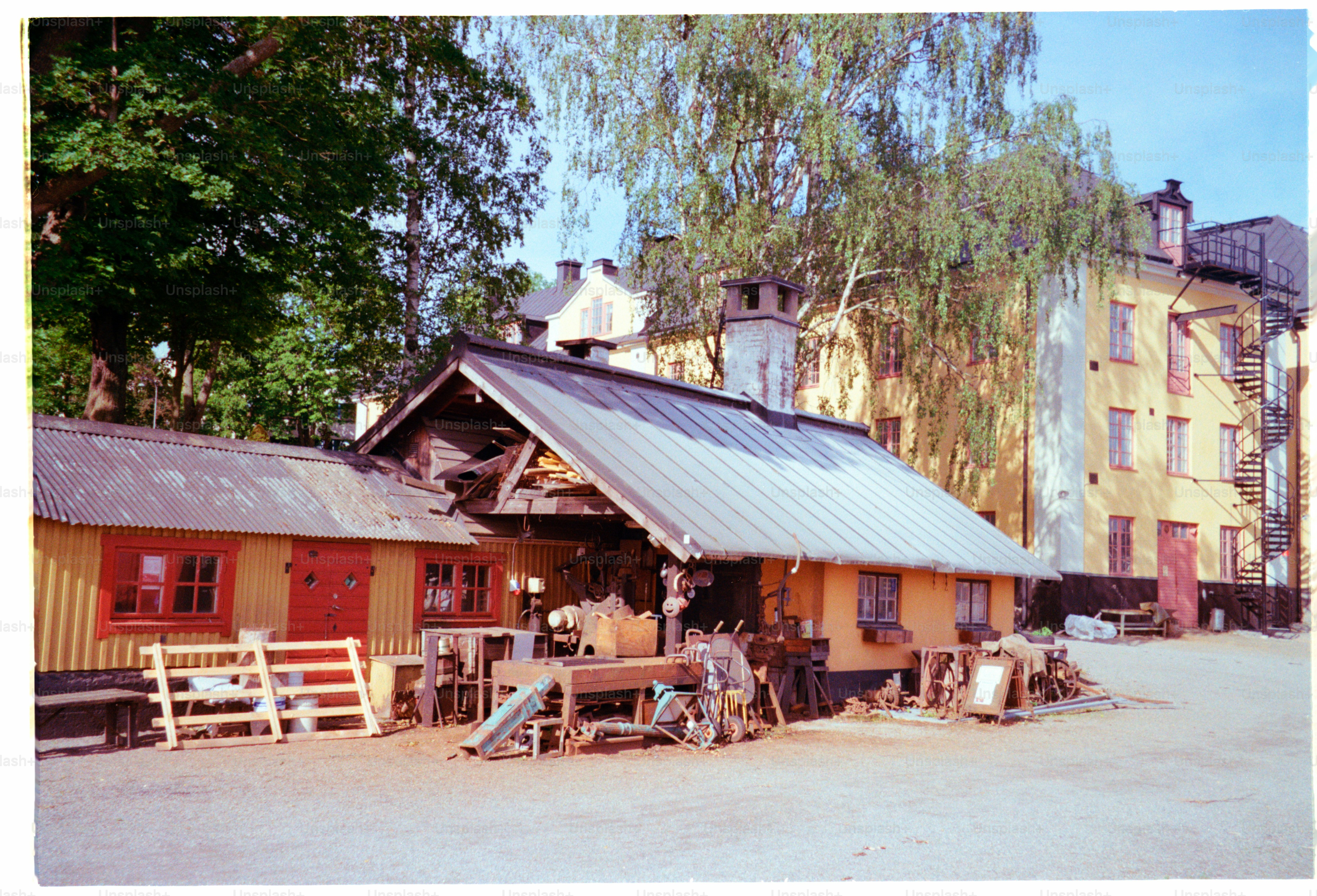 A rustic workshop sits in front of buildings.