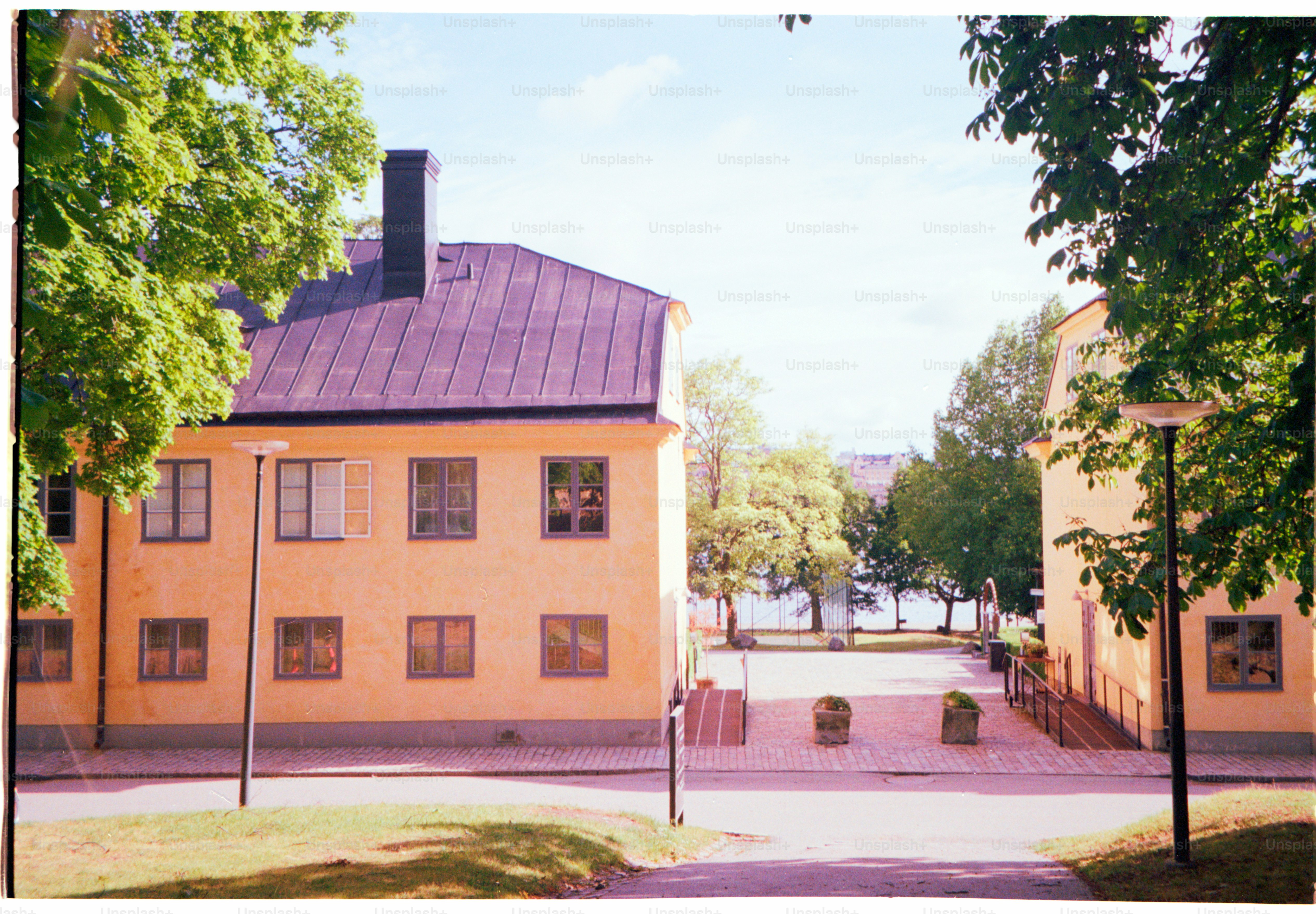 Buildings sit on a sunny day near trees.