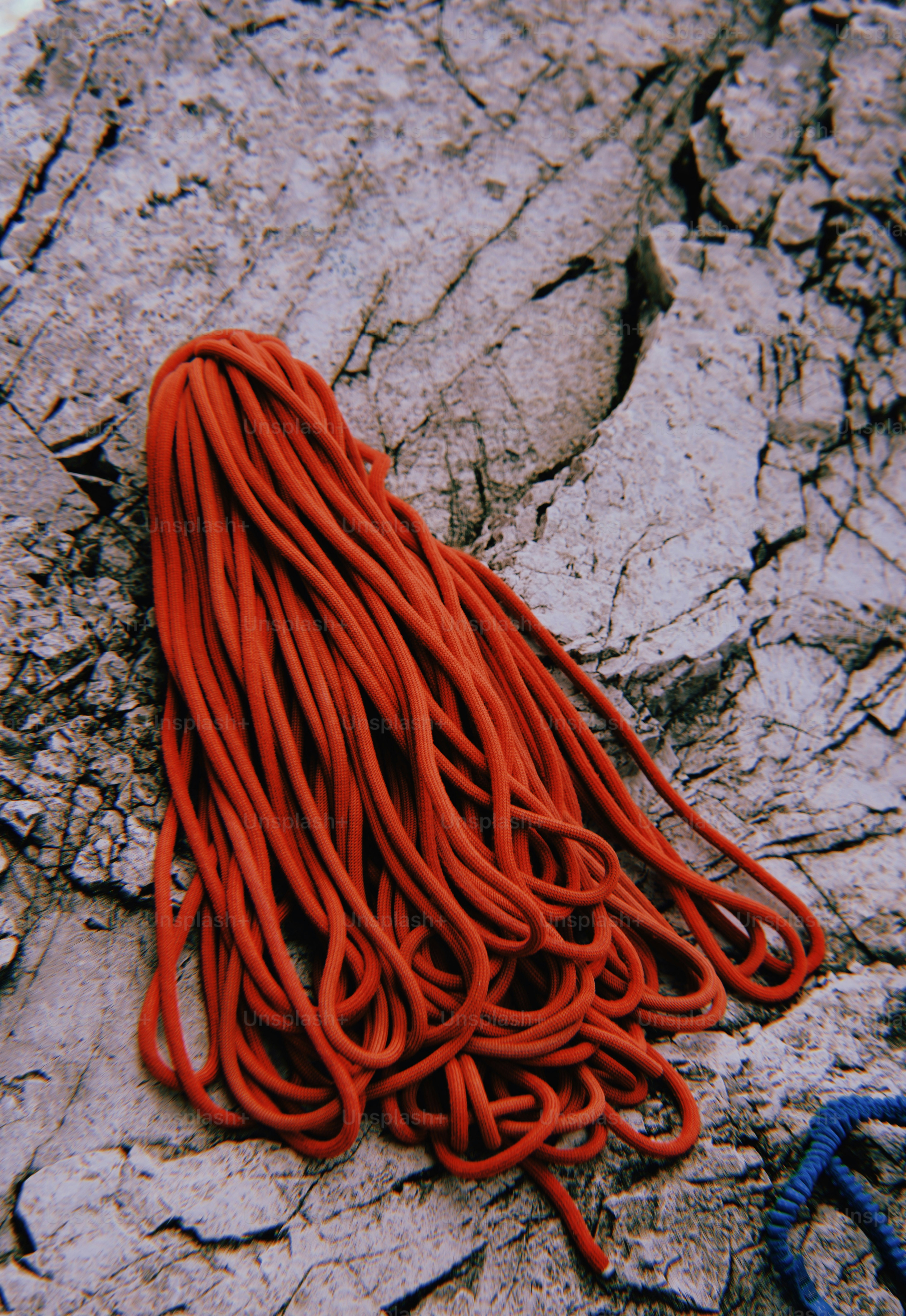 A corda de escalada vermelha encontra-se em uma superfície rochosa áspera