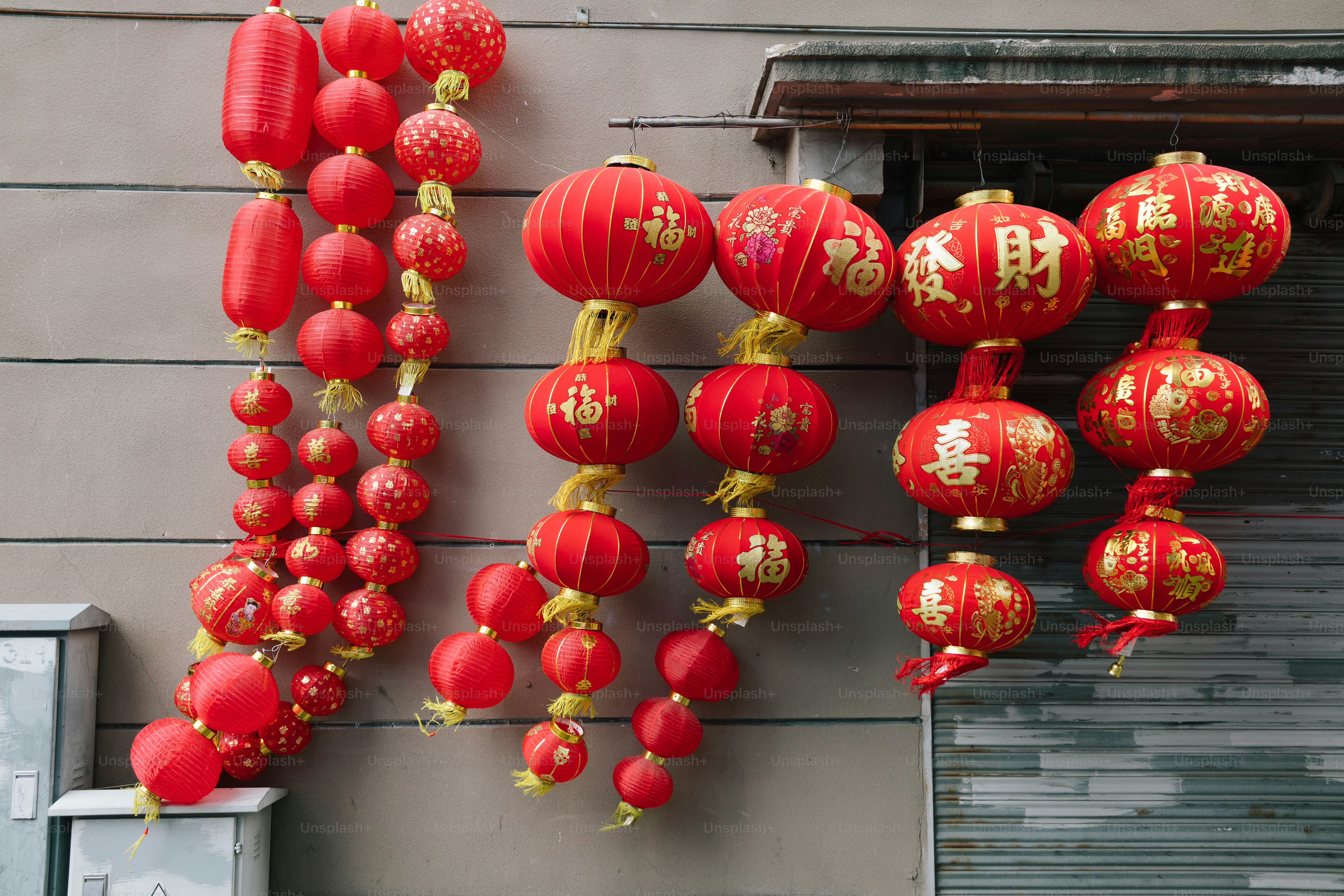 Red chinese lanterns decorate a wall.