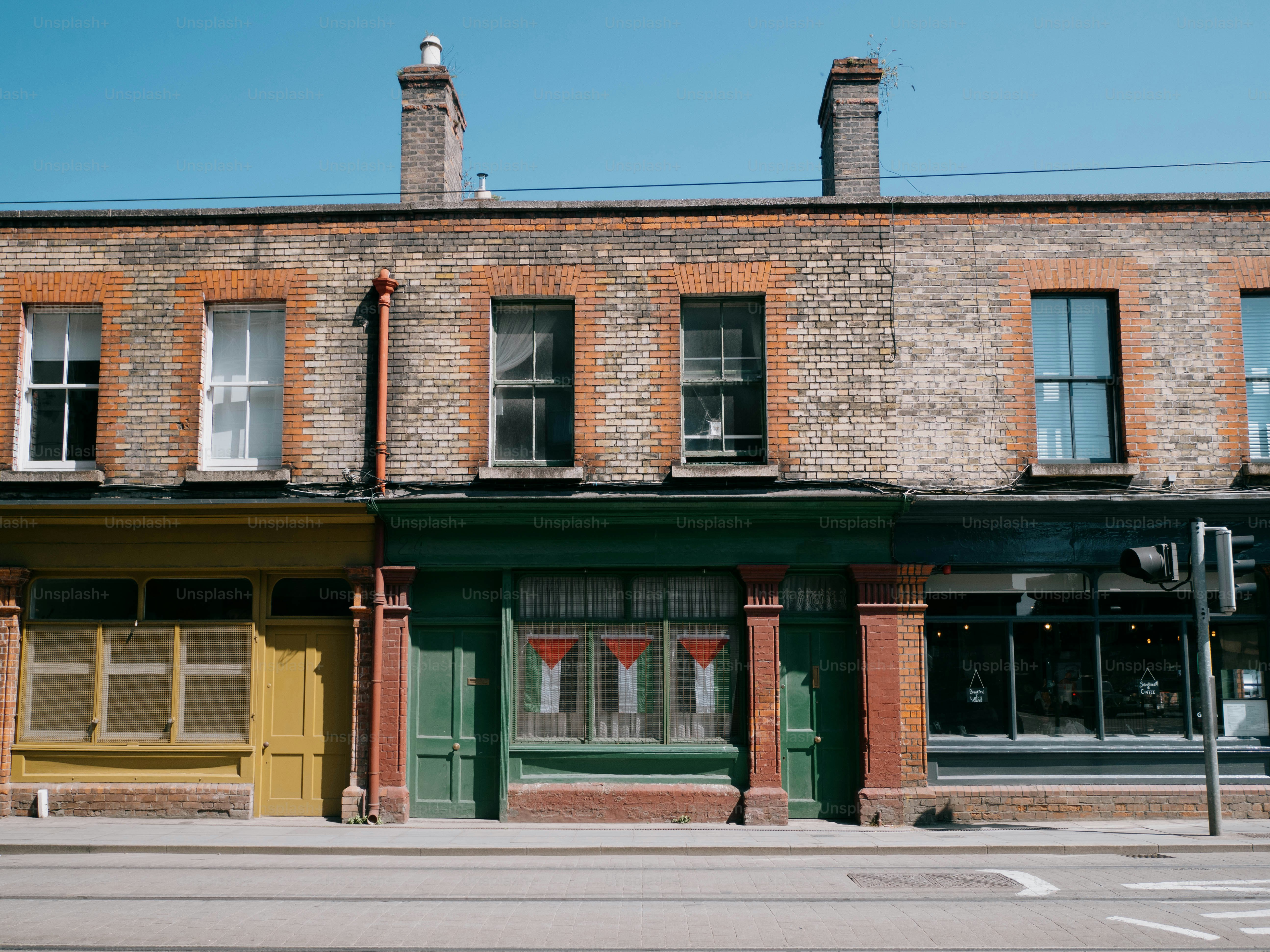 Old buildings line a street in the sunshine.