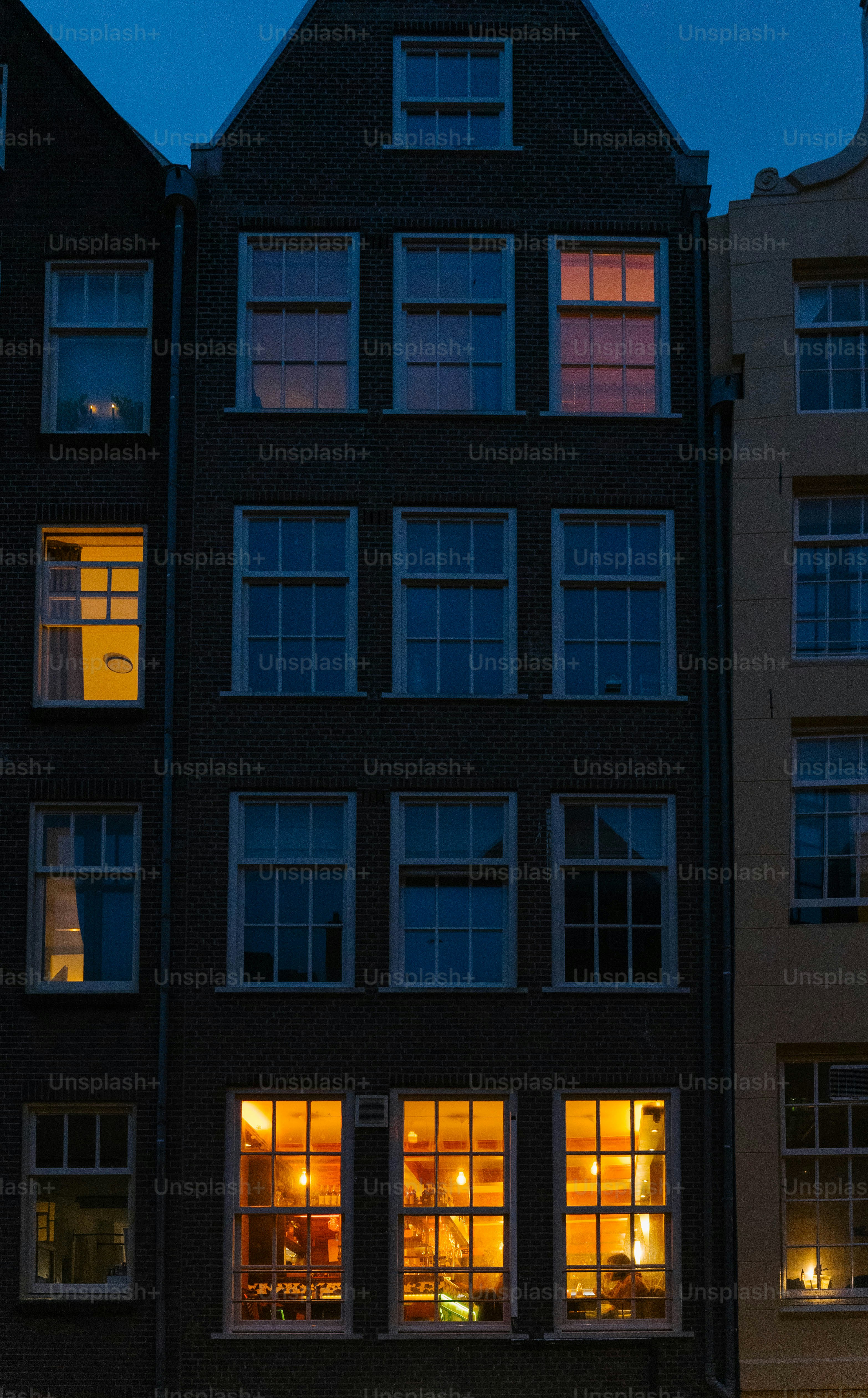 Lit windows illuminate the dark buildings at night.