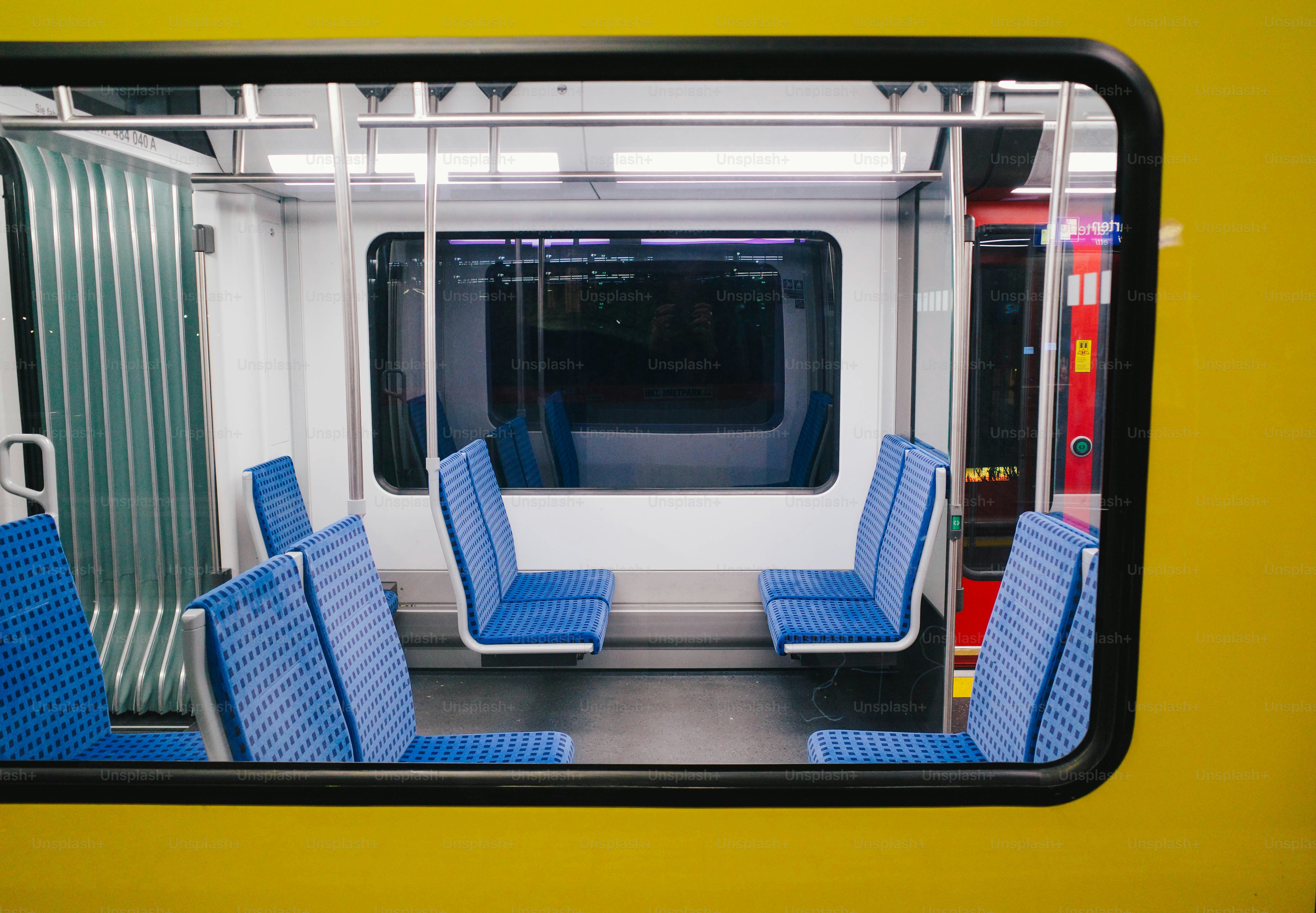 Inside of a modern train car with blue seats.