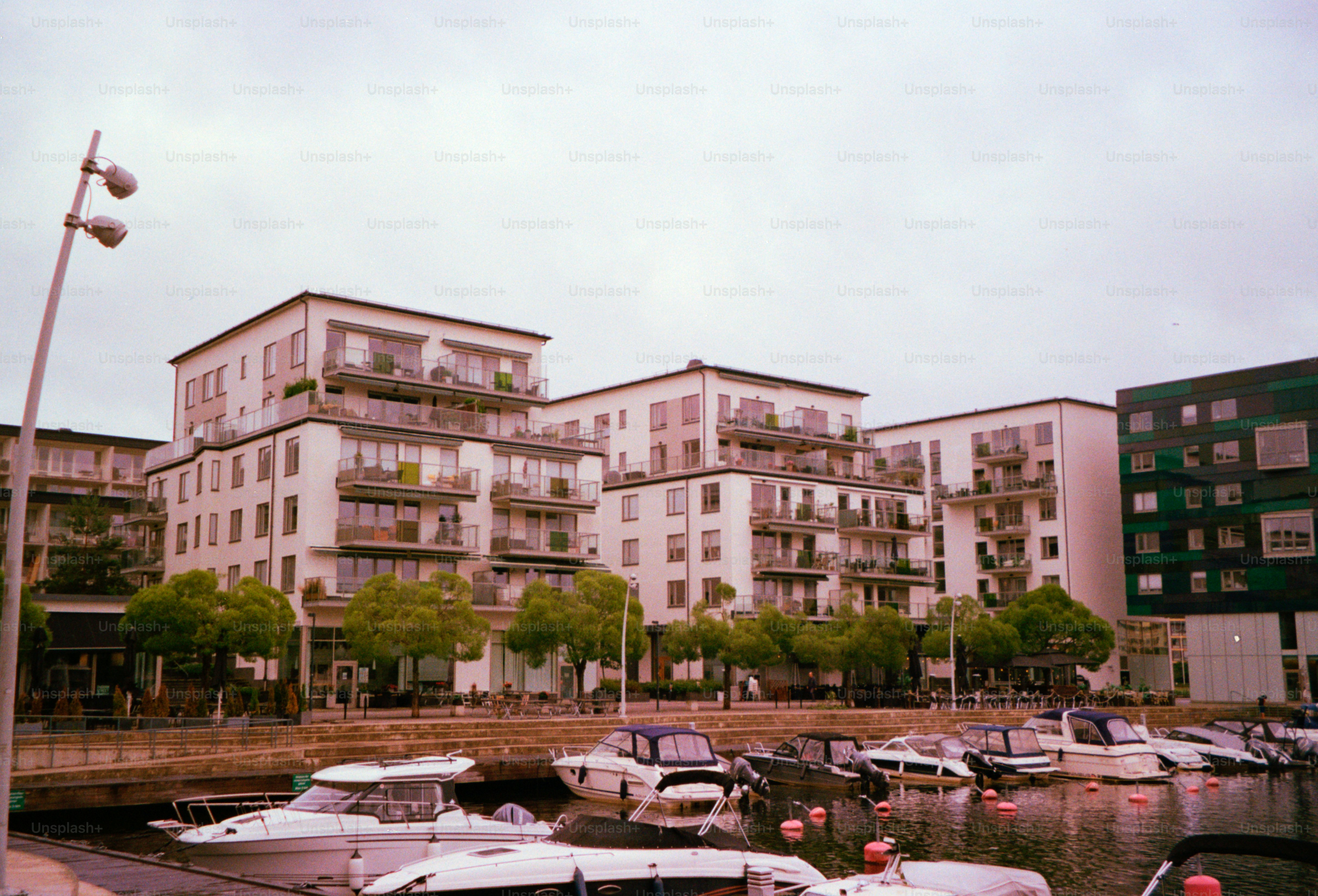 Modern buildings overlook a marina filled with boats.