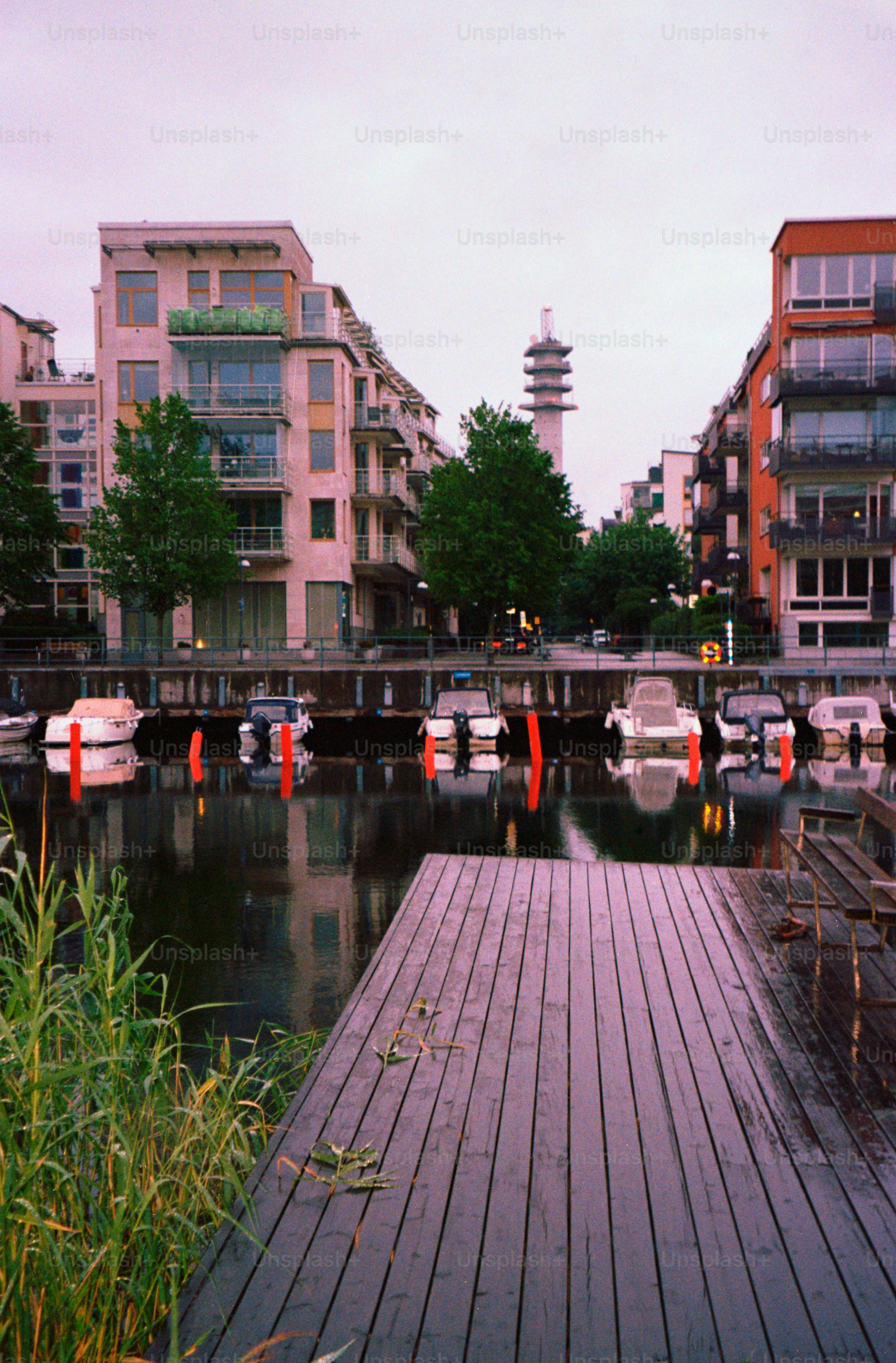 Boats and buildings line a peaceful waterfront.