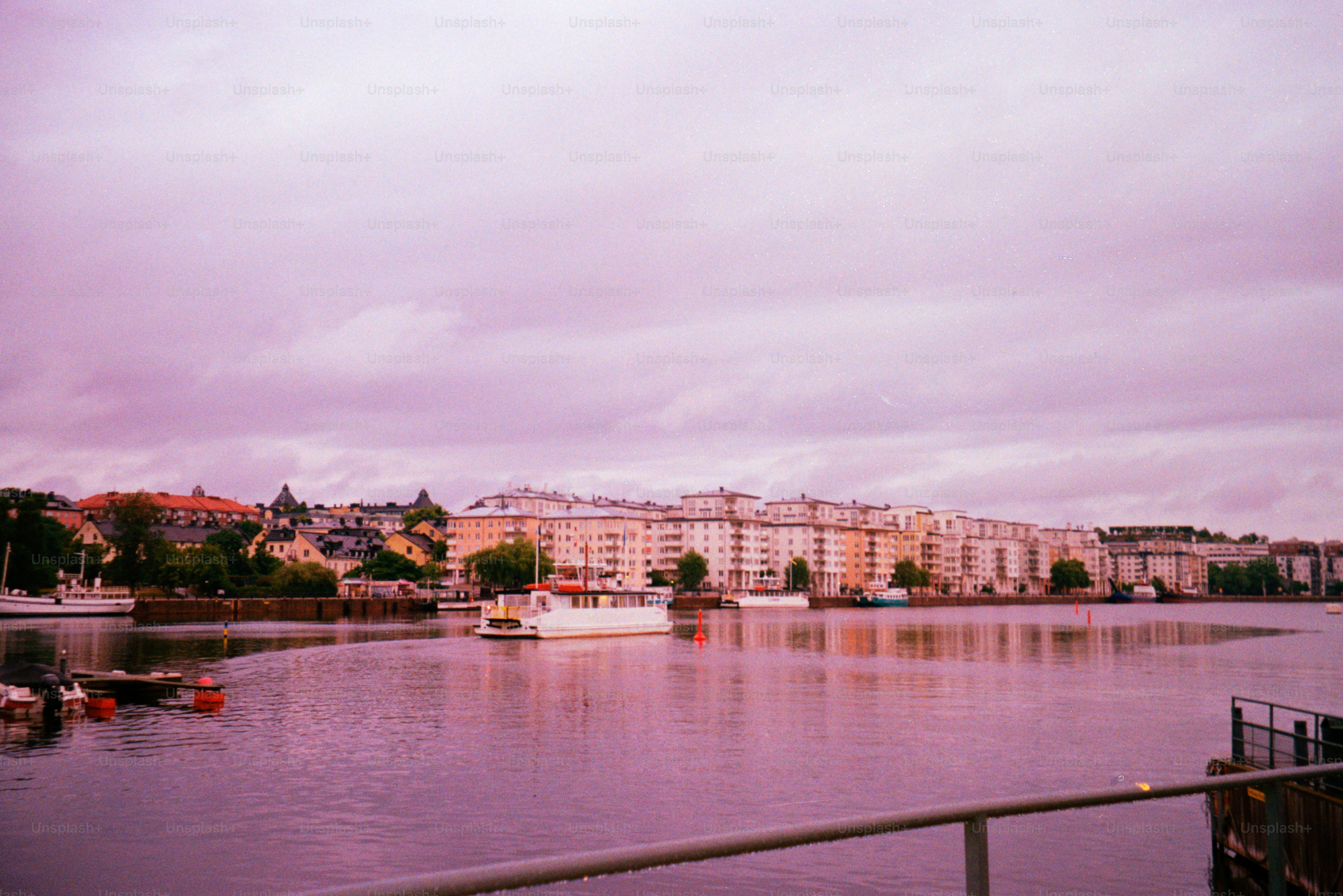 Buildings and a lake under a purple sky.