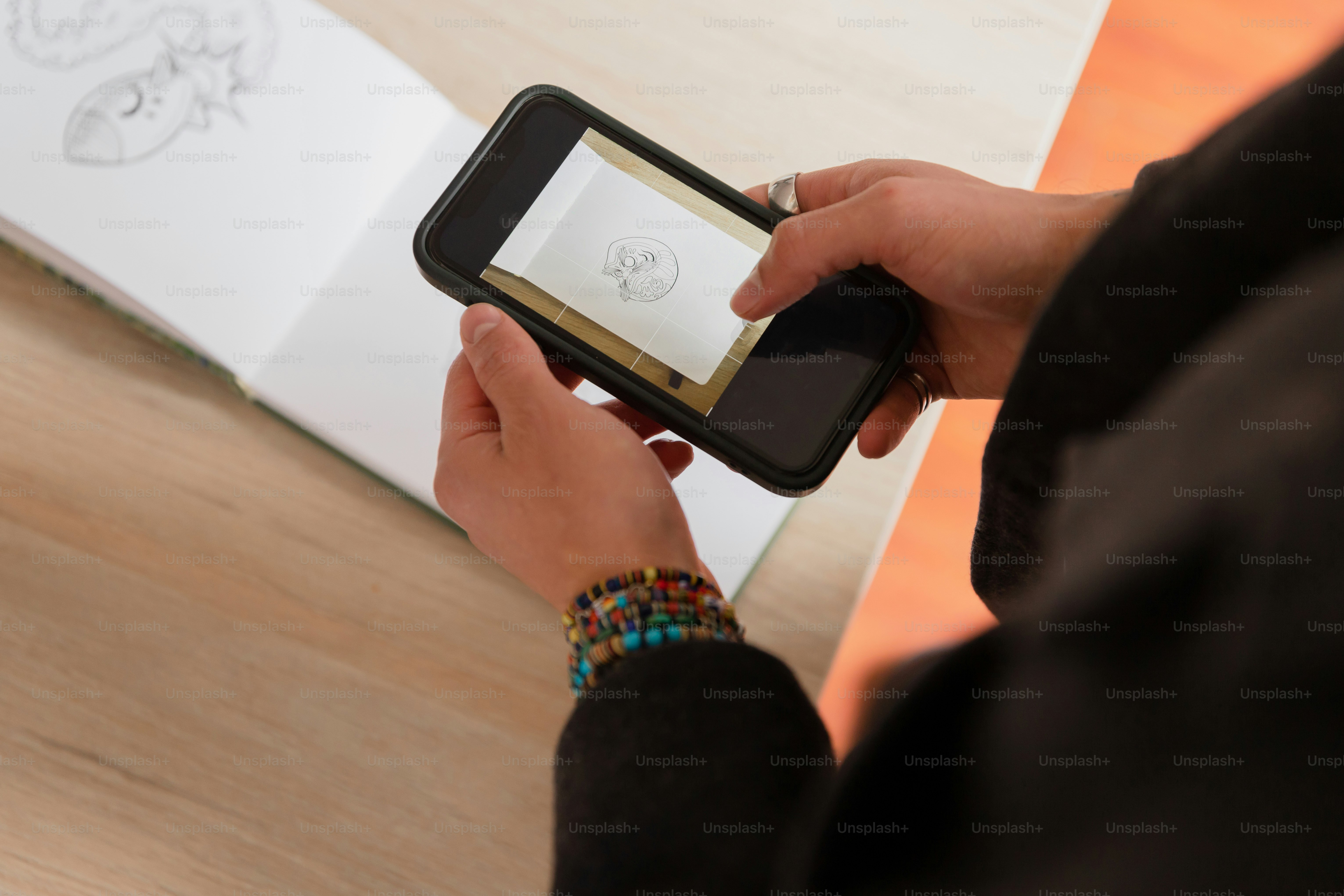 Person taking a picture of a drawing with their phone.