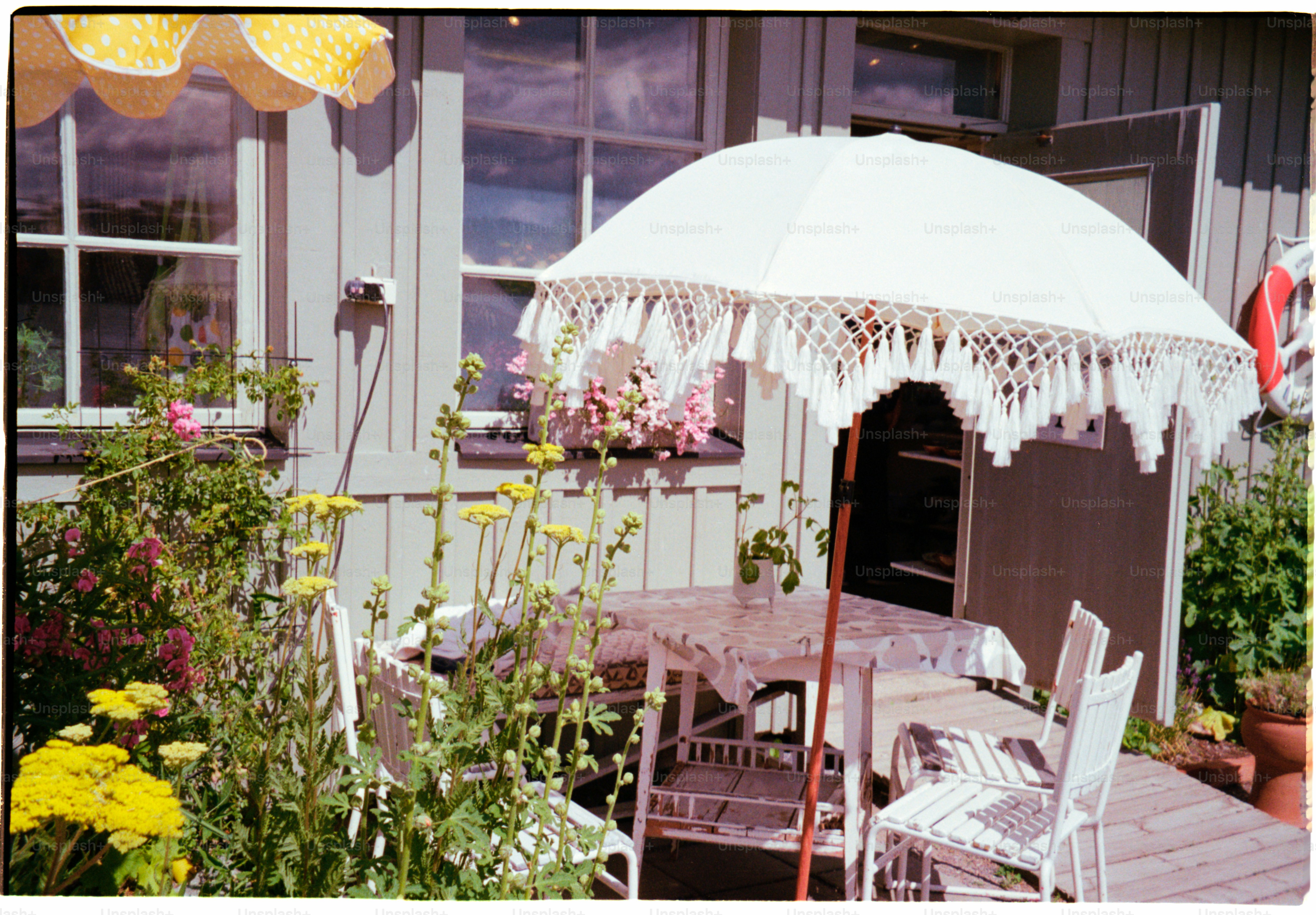 A quaint outdoor table is sheltered by parasols.