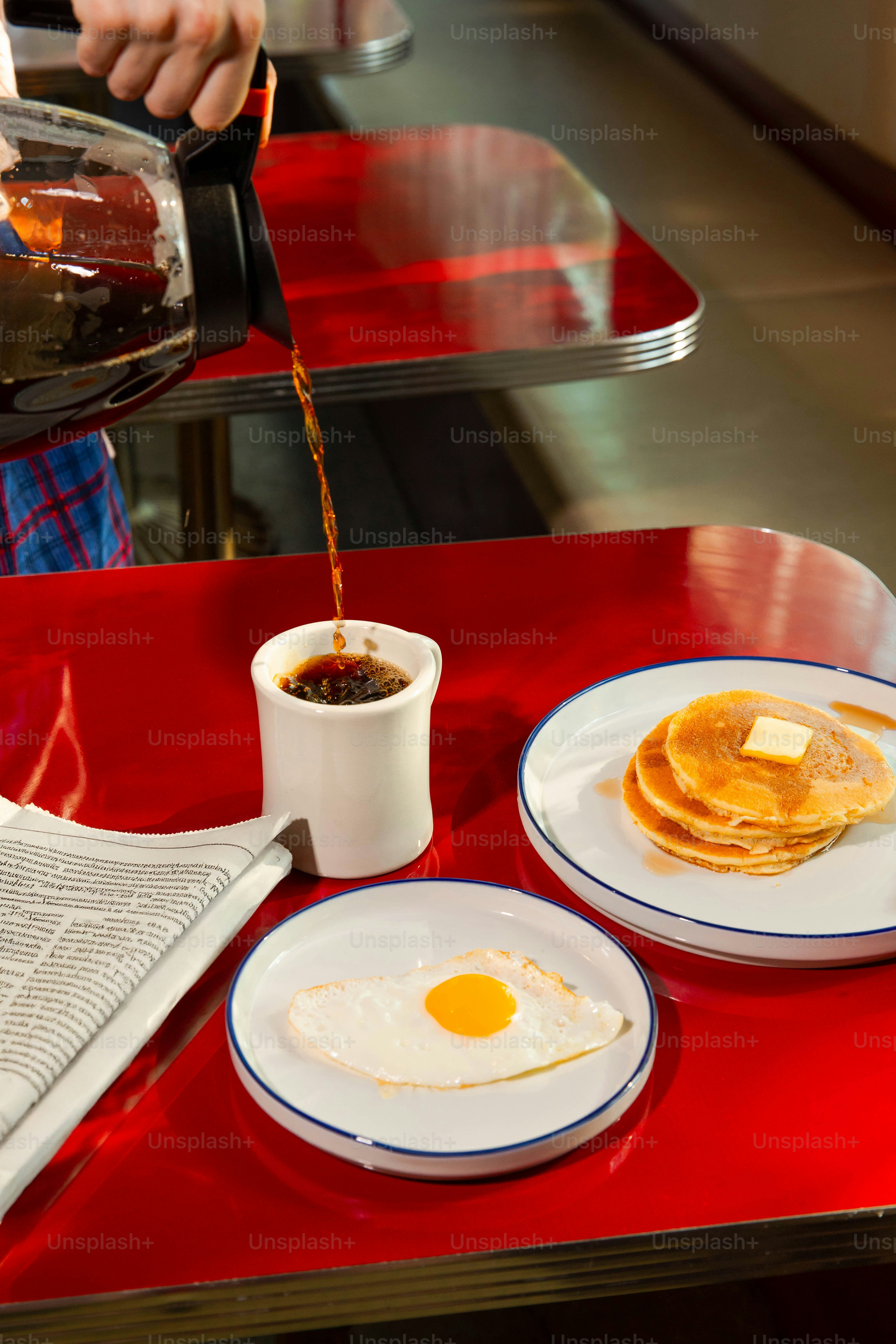 Coffee is poured with breakfast on a diner table