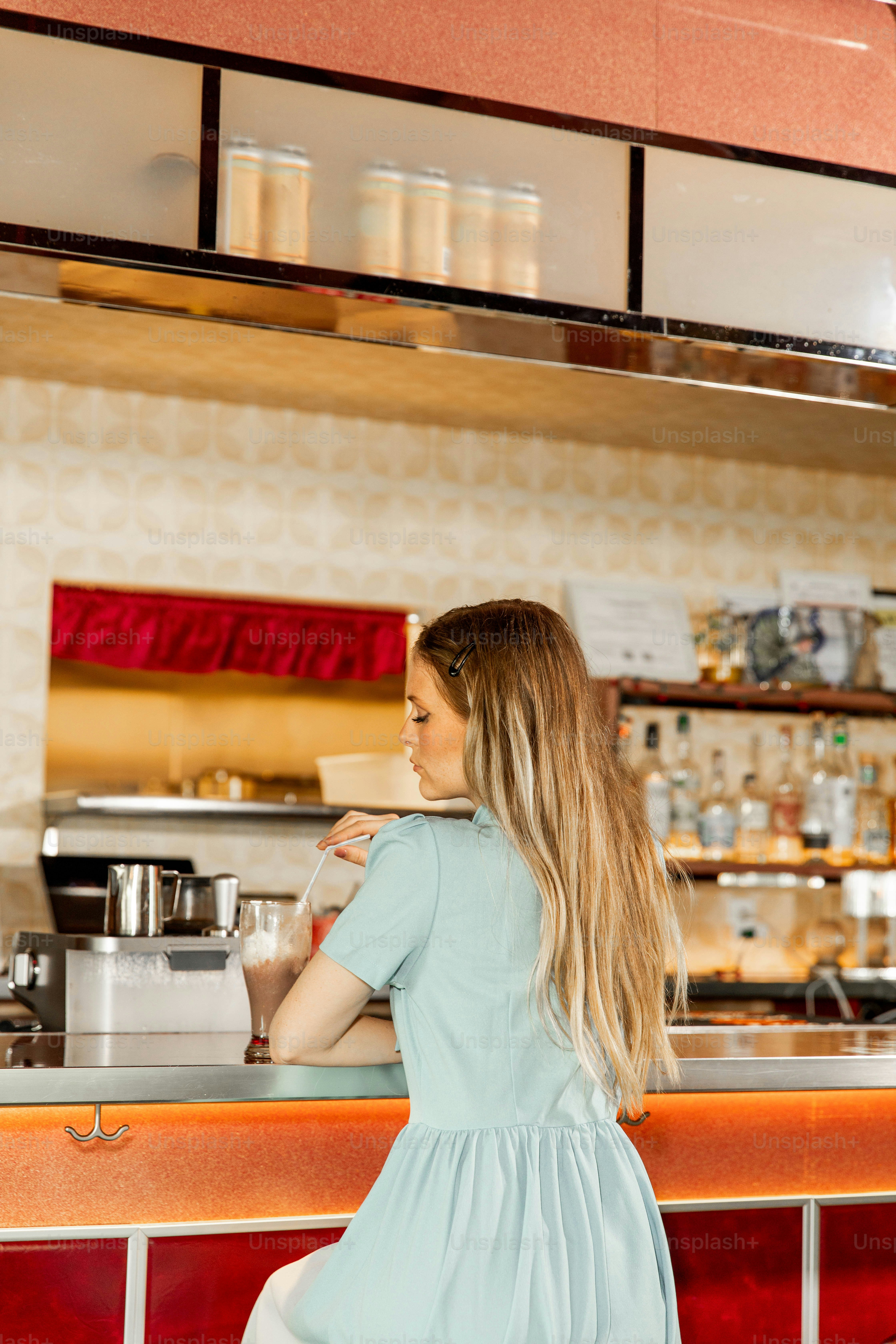 Woman sits alone at a diner counter.