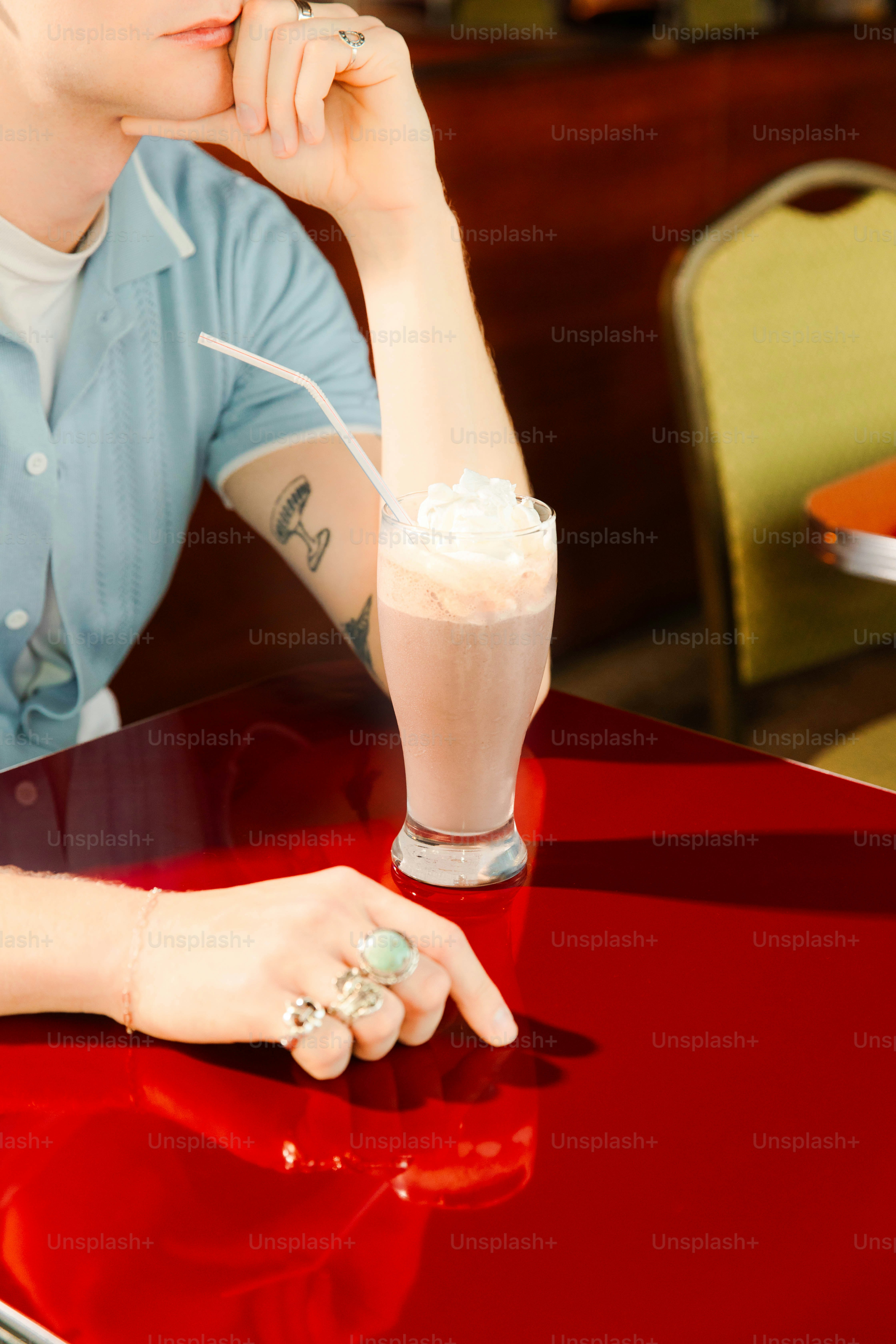 A person with a milkshake at a diner.