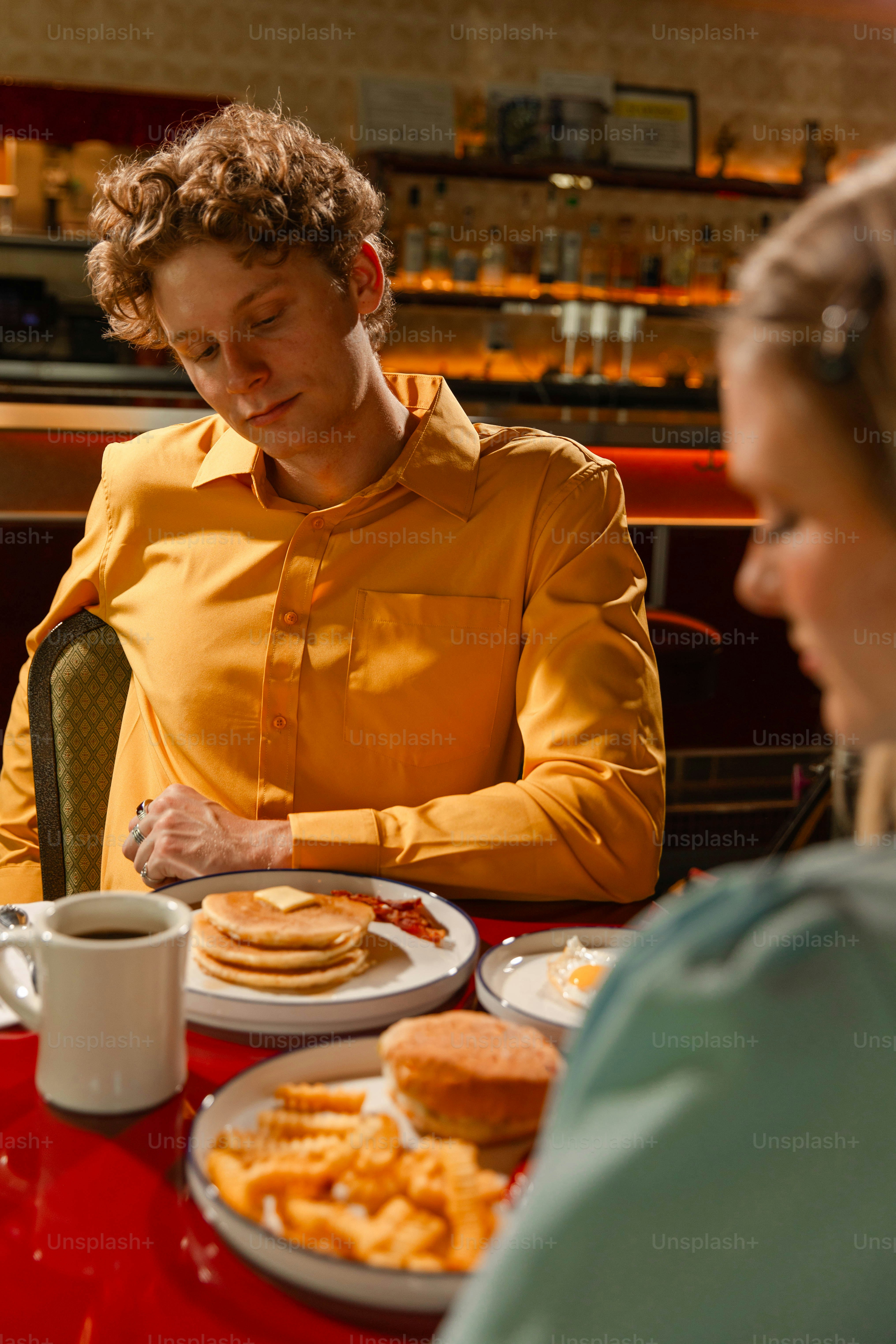 Two people eat breakfast at a diner.