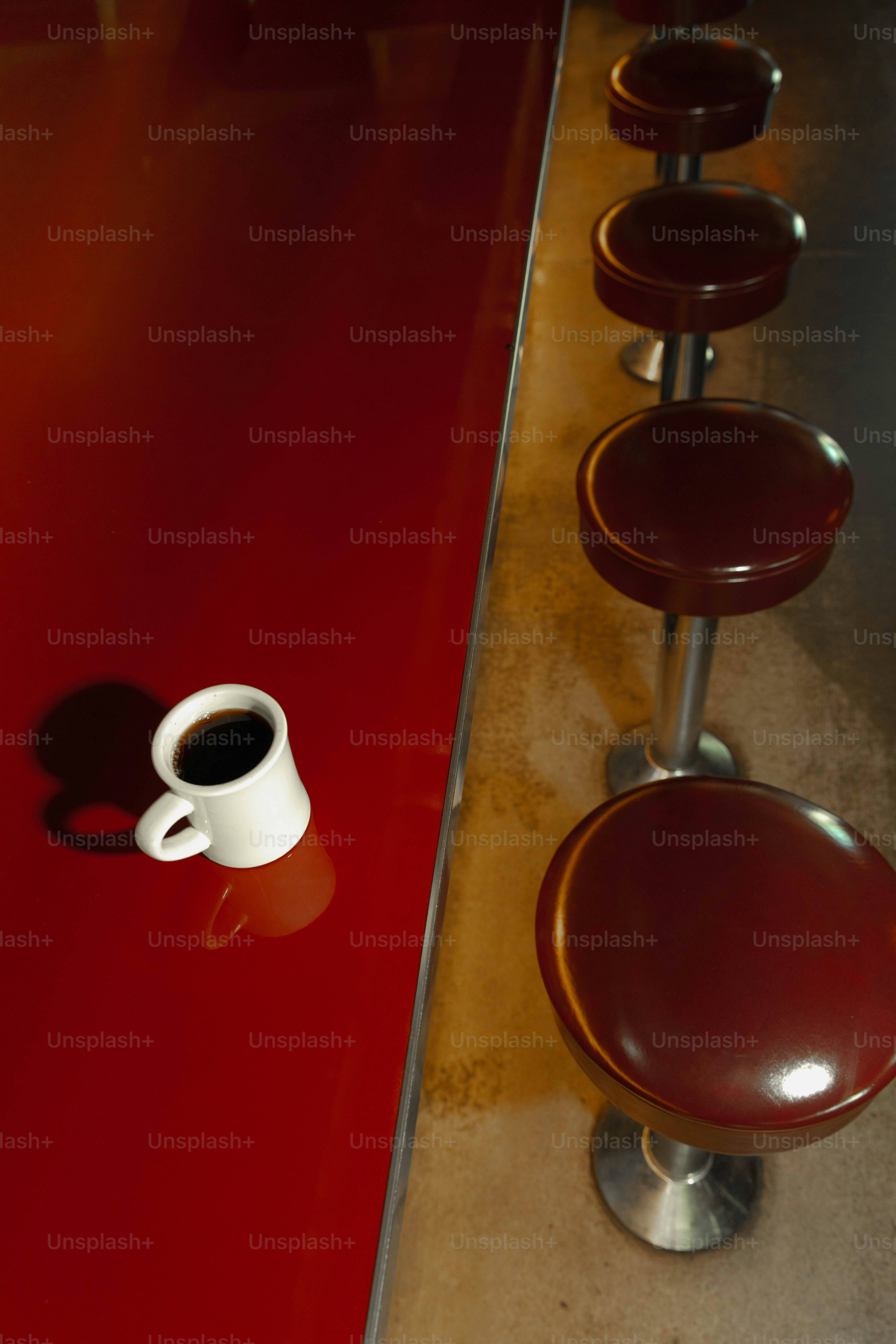 A coffee cup sits alone on the red counter.