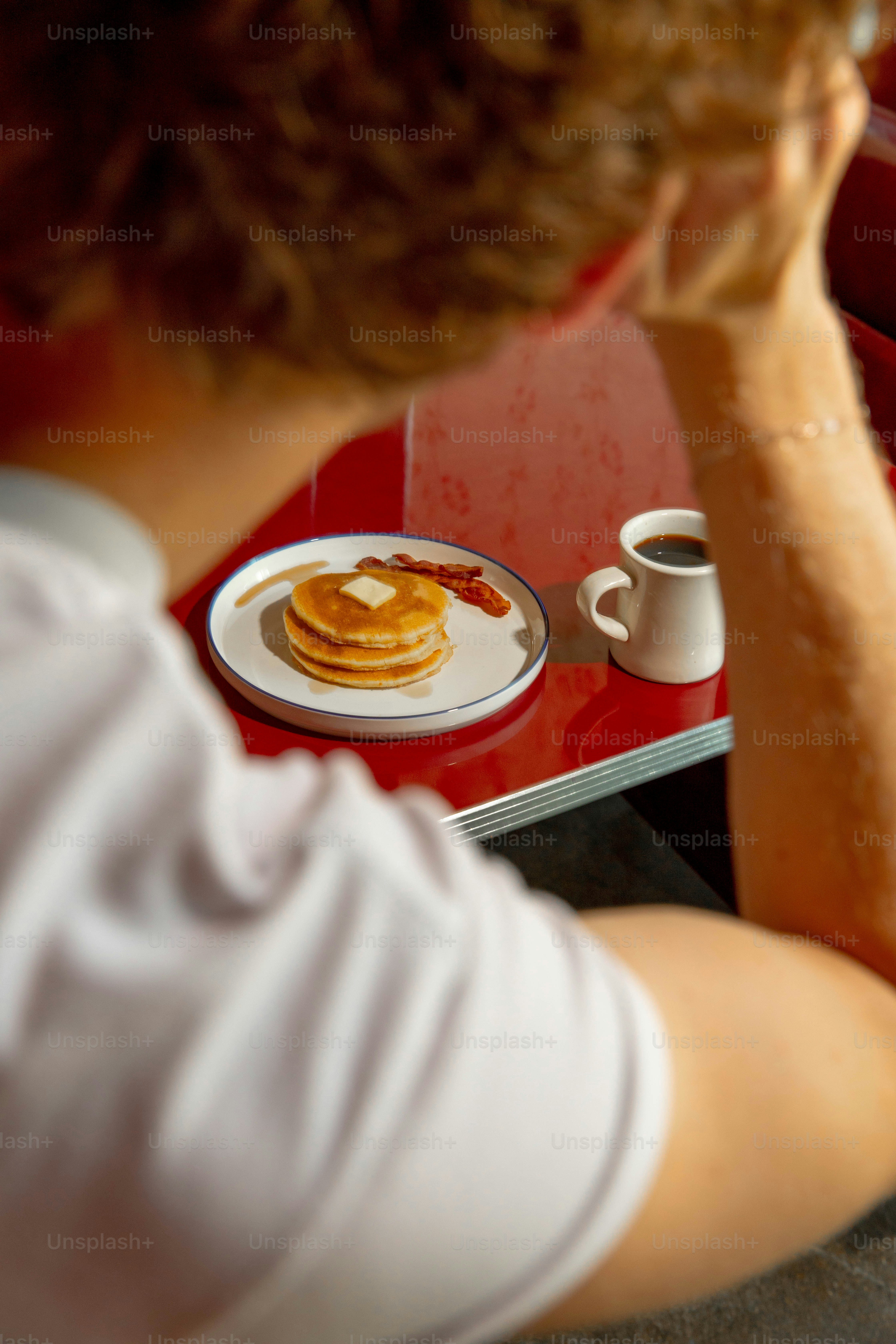 Alguém está desfrutando do café da manhã com panquecas e café
