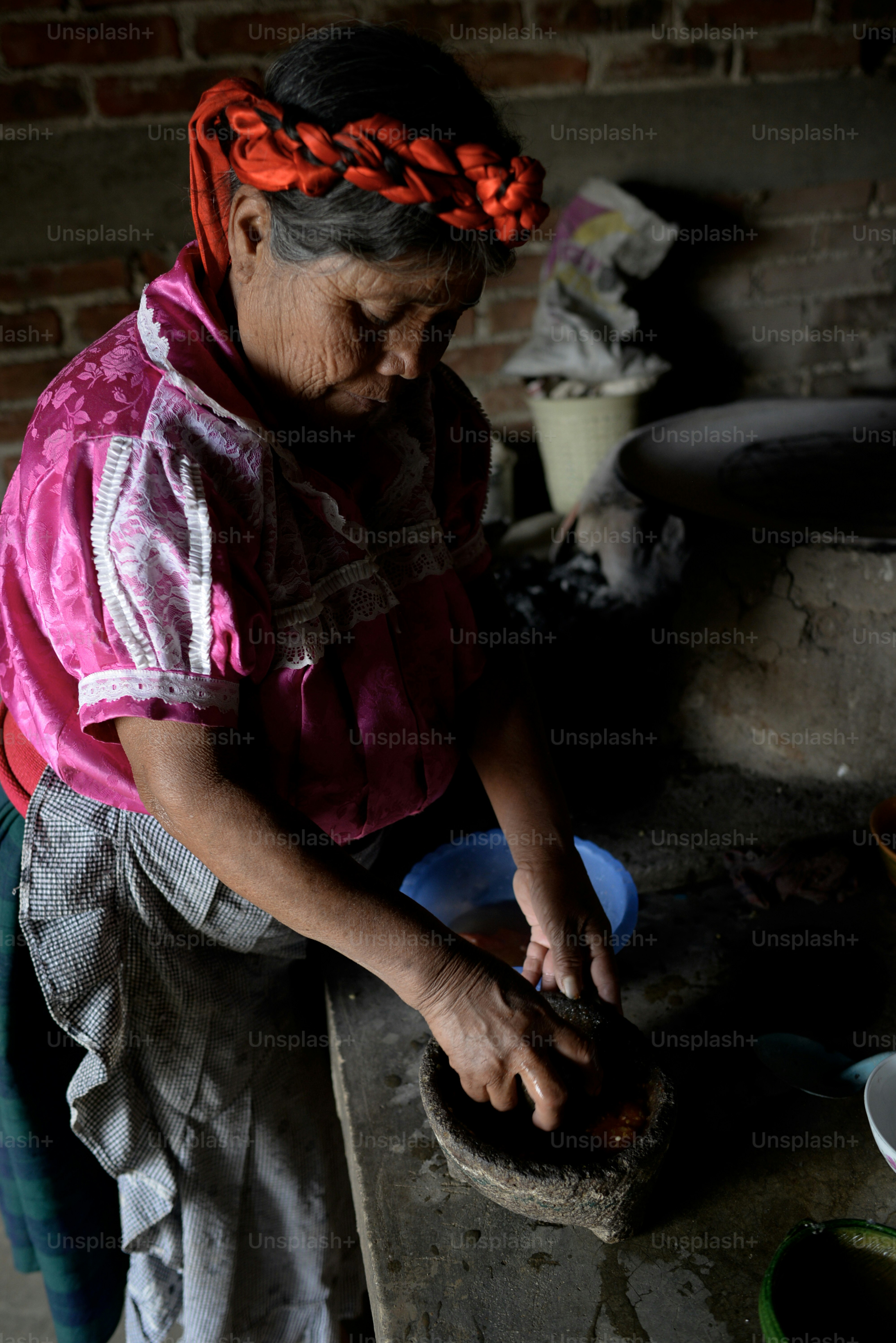 伝統的な衣装を着た女性が食べ物を準備します。
