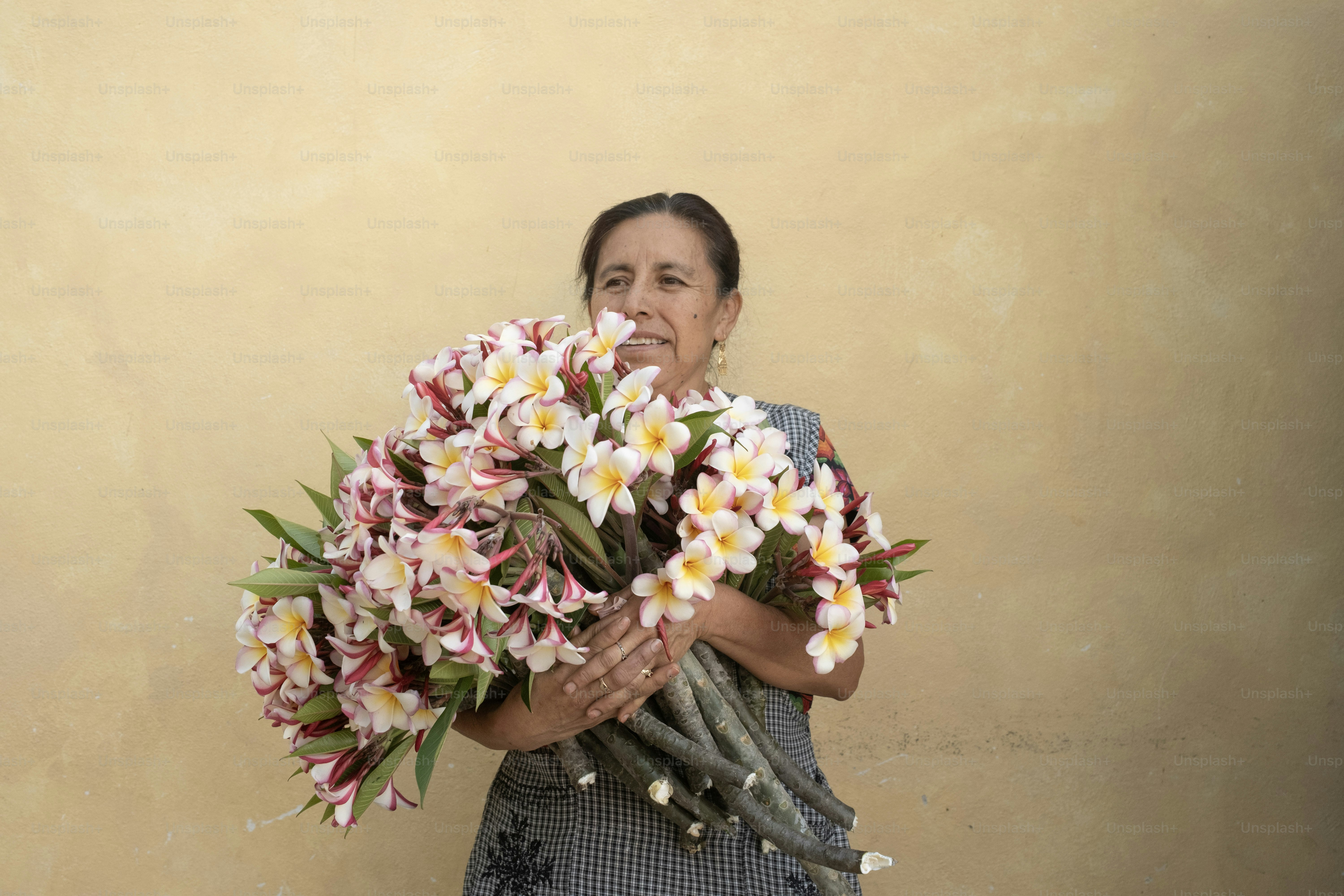 女性は美しい花の大きな花束を持っています。