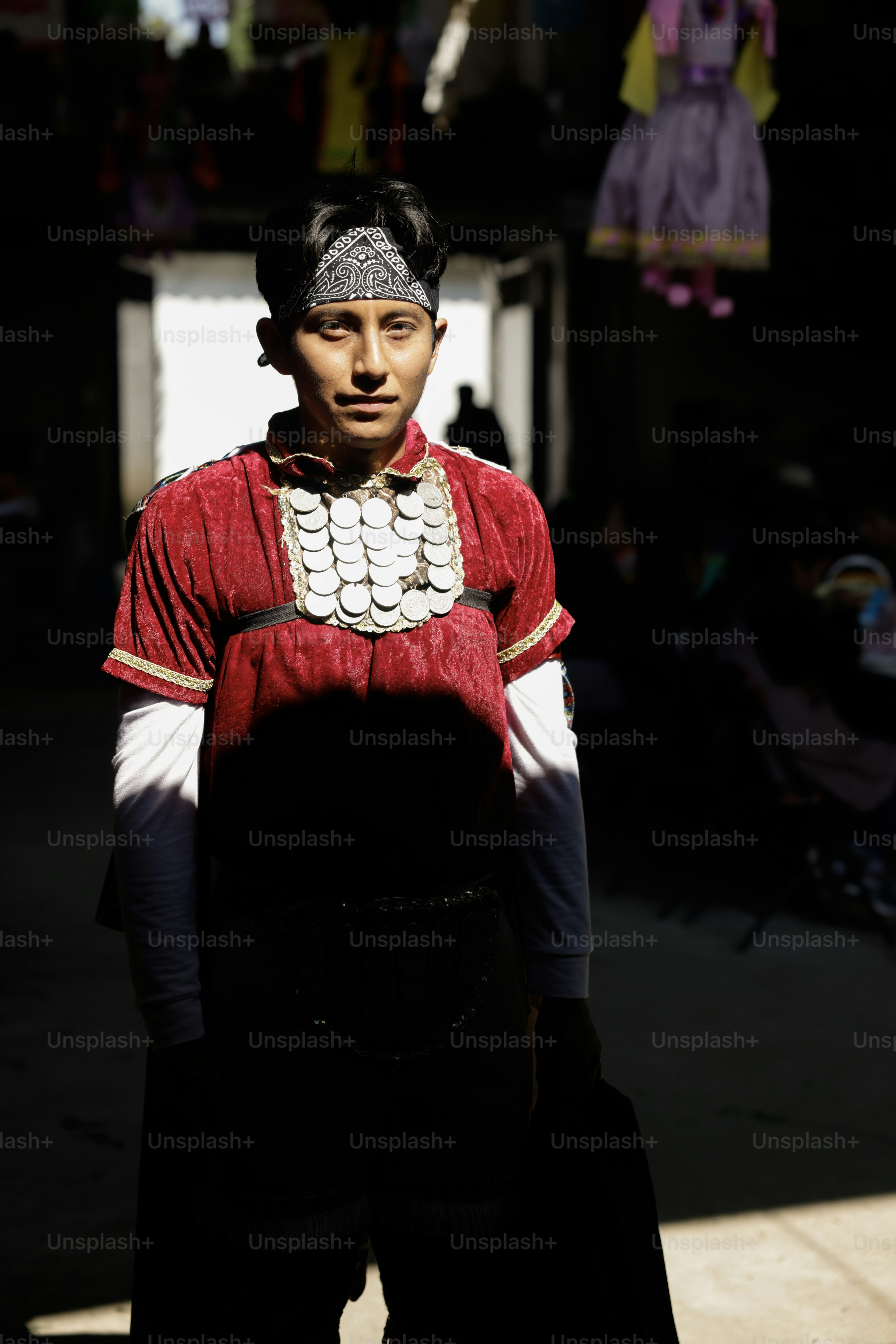 Seorang pemuda berpose dengan pakaian tradisional.