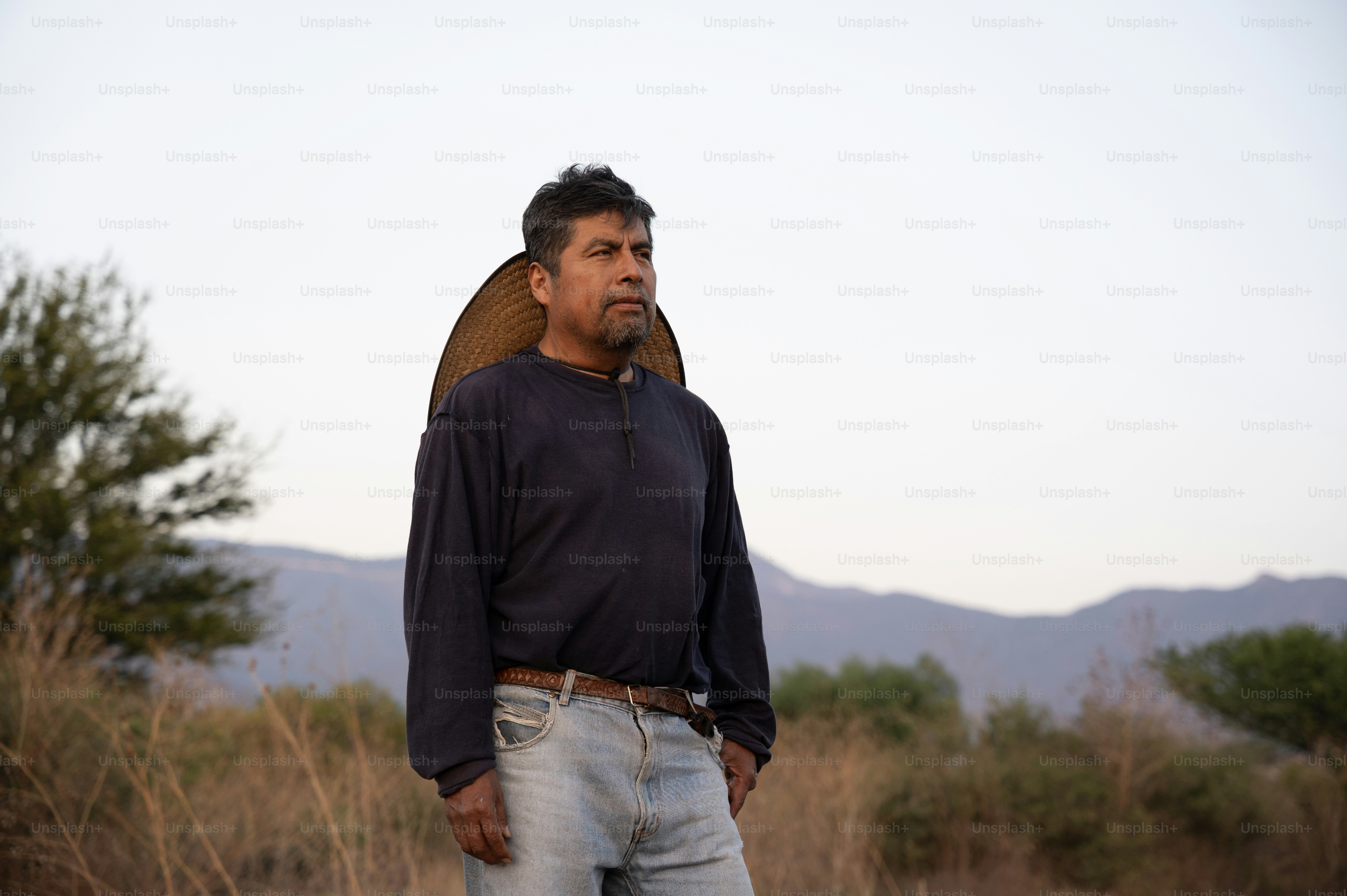 一人の男性が屋外に立って前を見つめている。