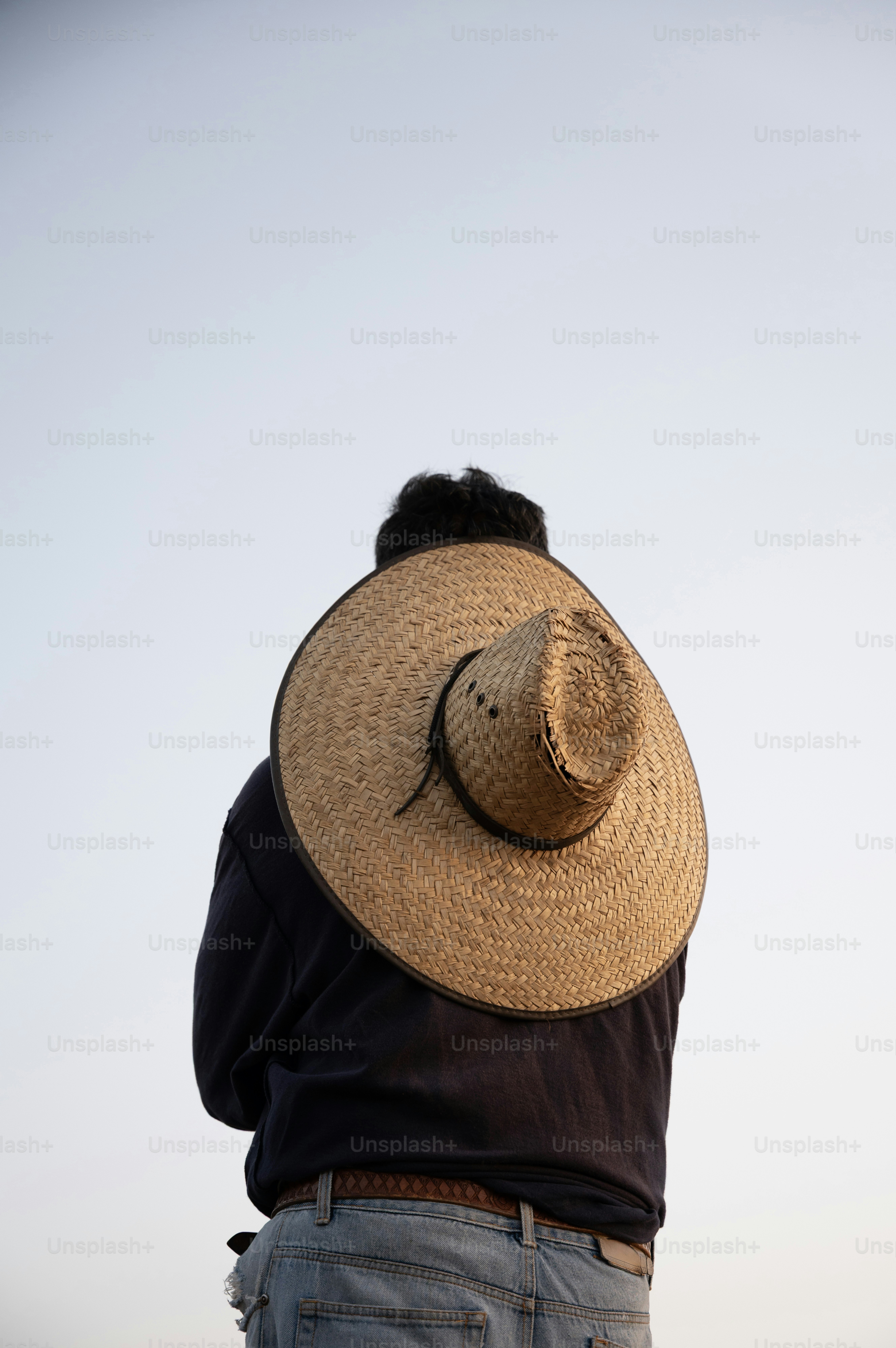 Mann mit einem Strohhut über den Schultern.